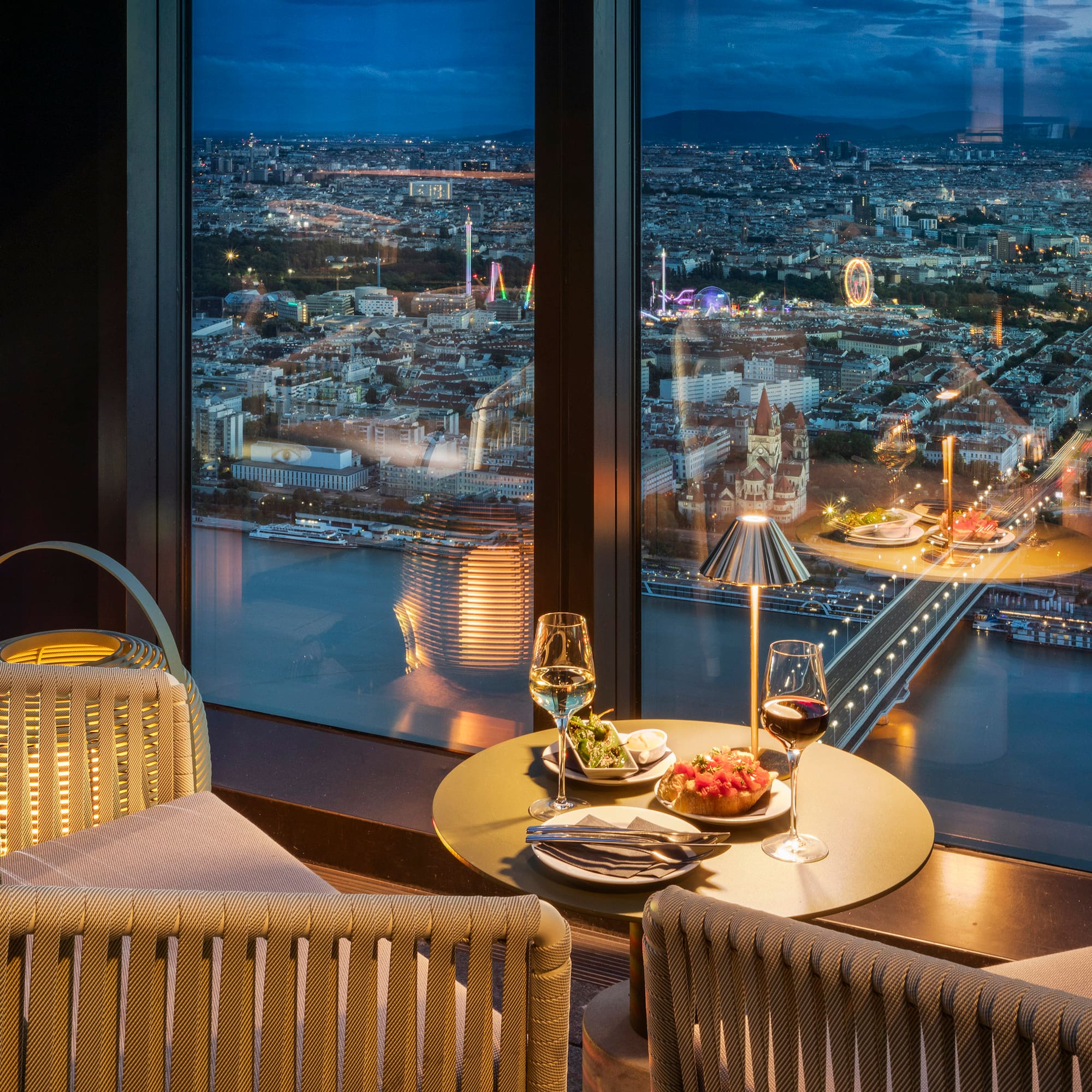 a table with food and wine in front of a window