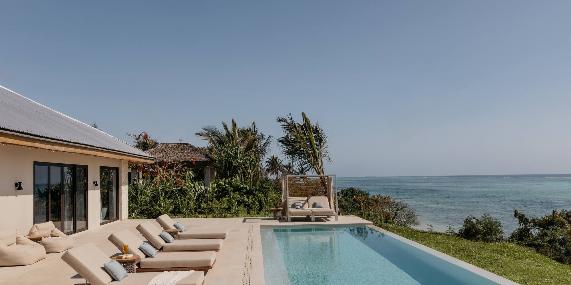 a pool with lounge chairs and a beach view