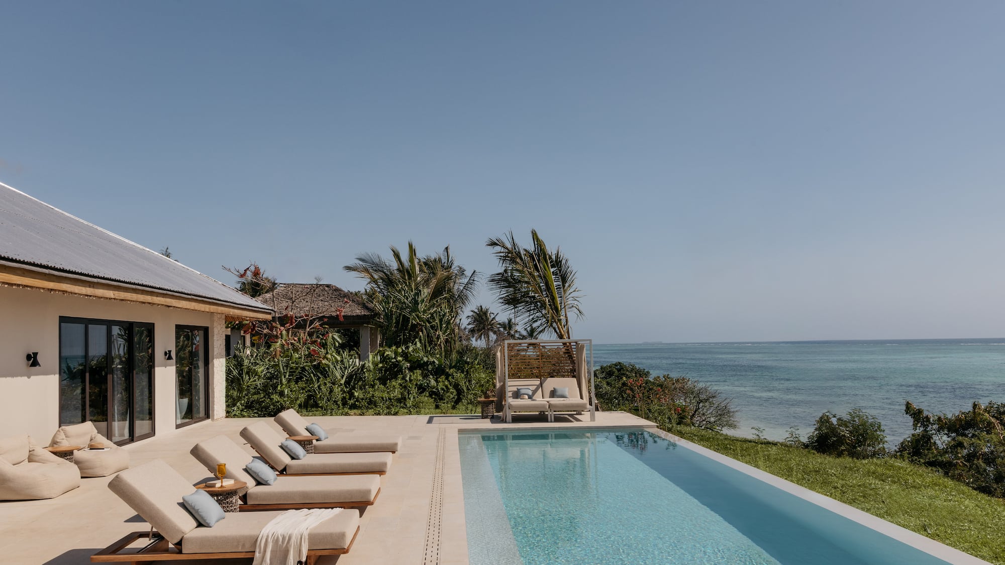 a pool with lounge chairs and a beach view