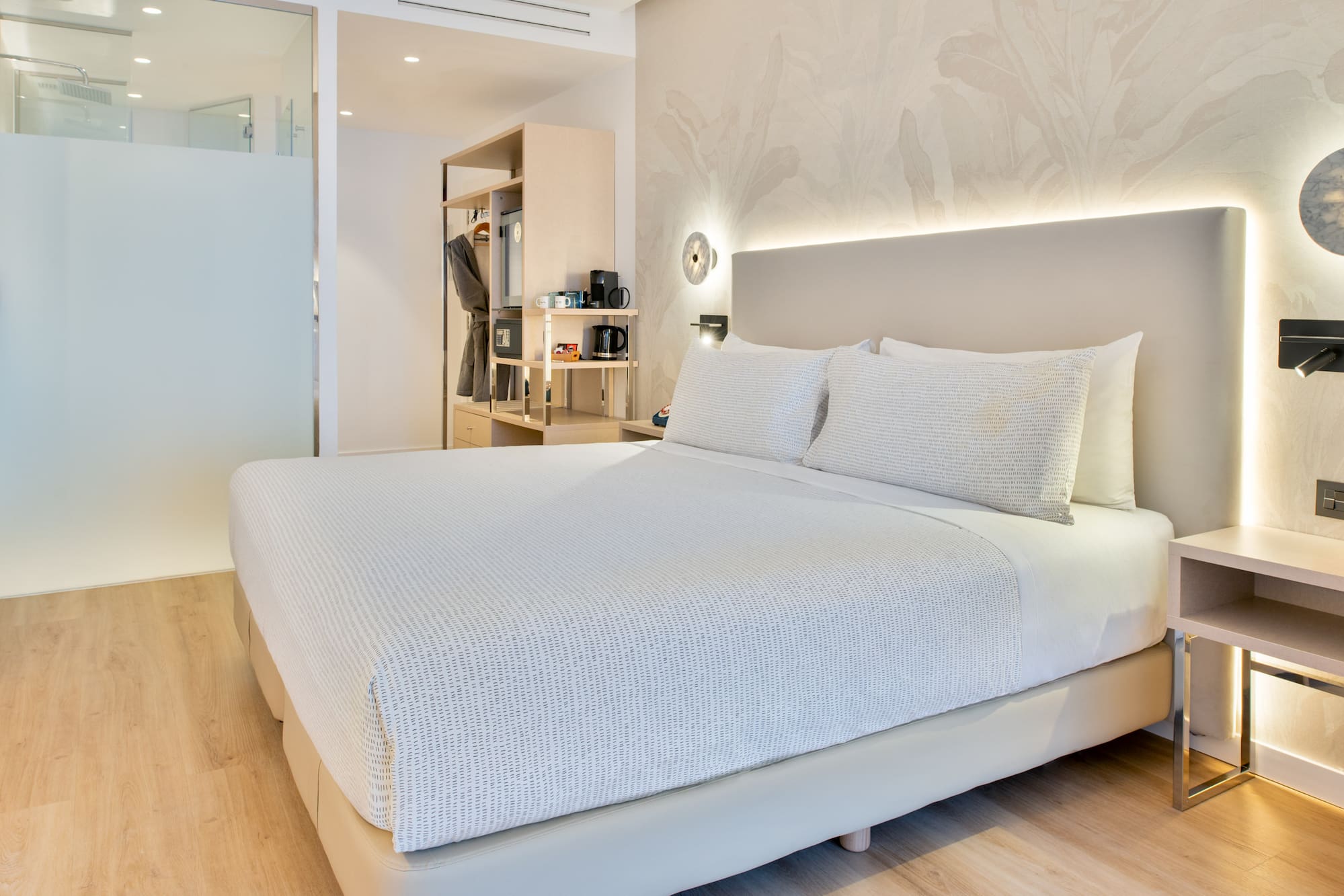 a bed with white sheets and pillows in a room