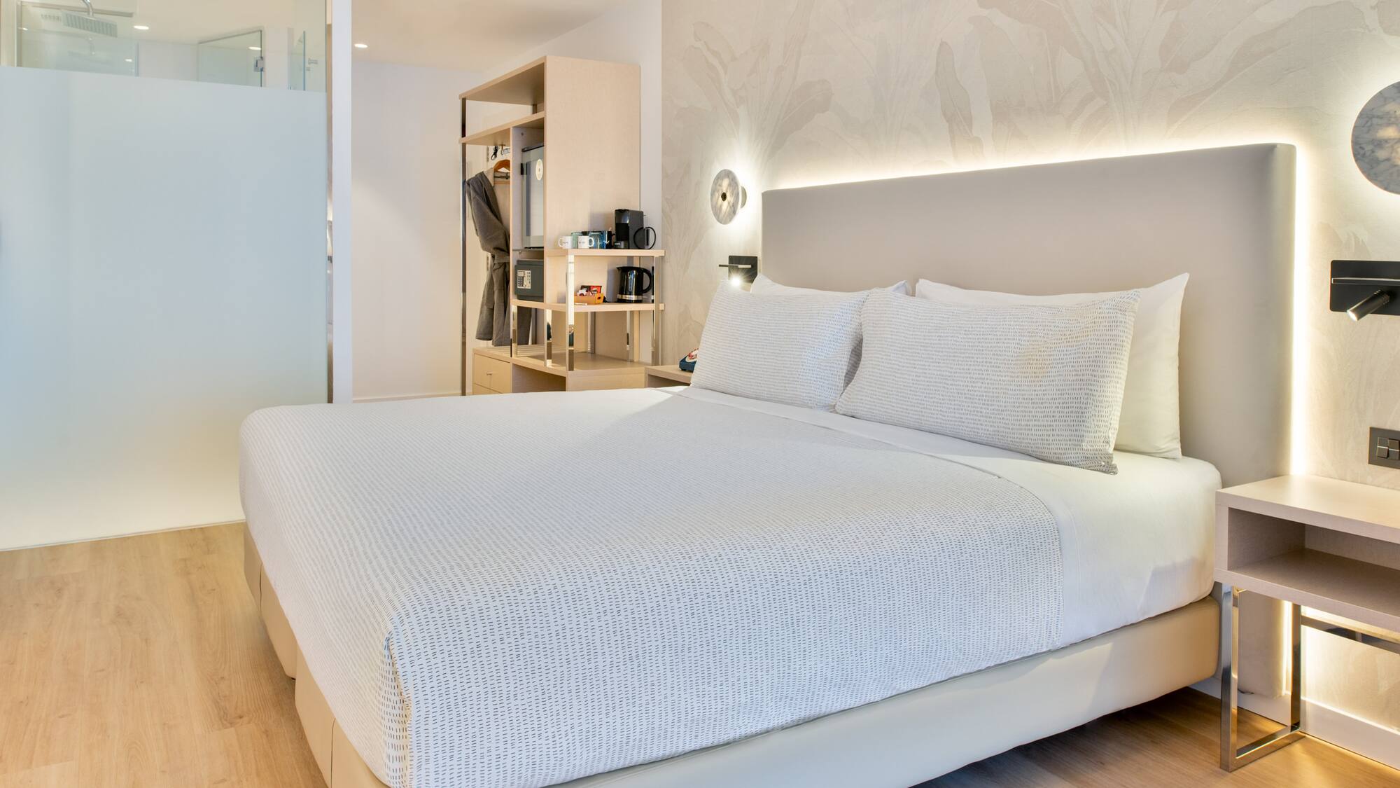 a bed with white sheets and pillows in a room