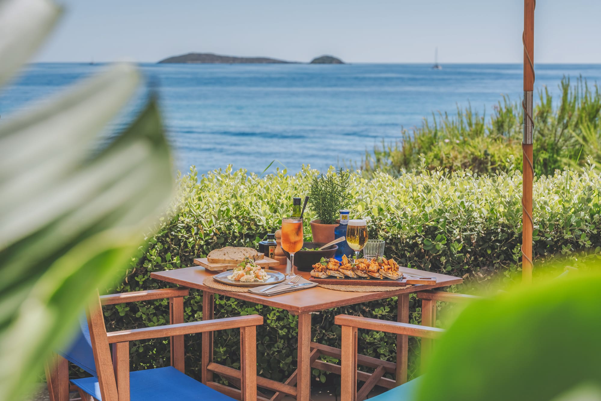 Mediterranean outdoor dining with tapas, drinks, and sea view.