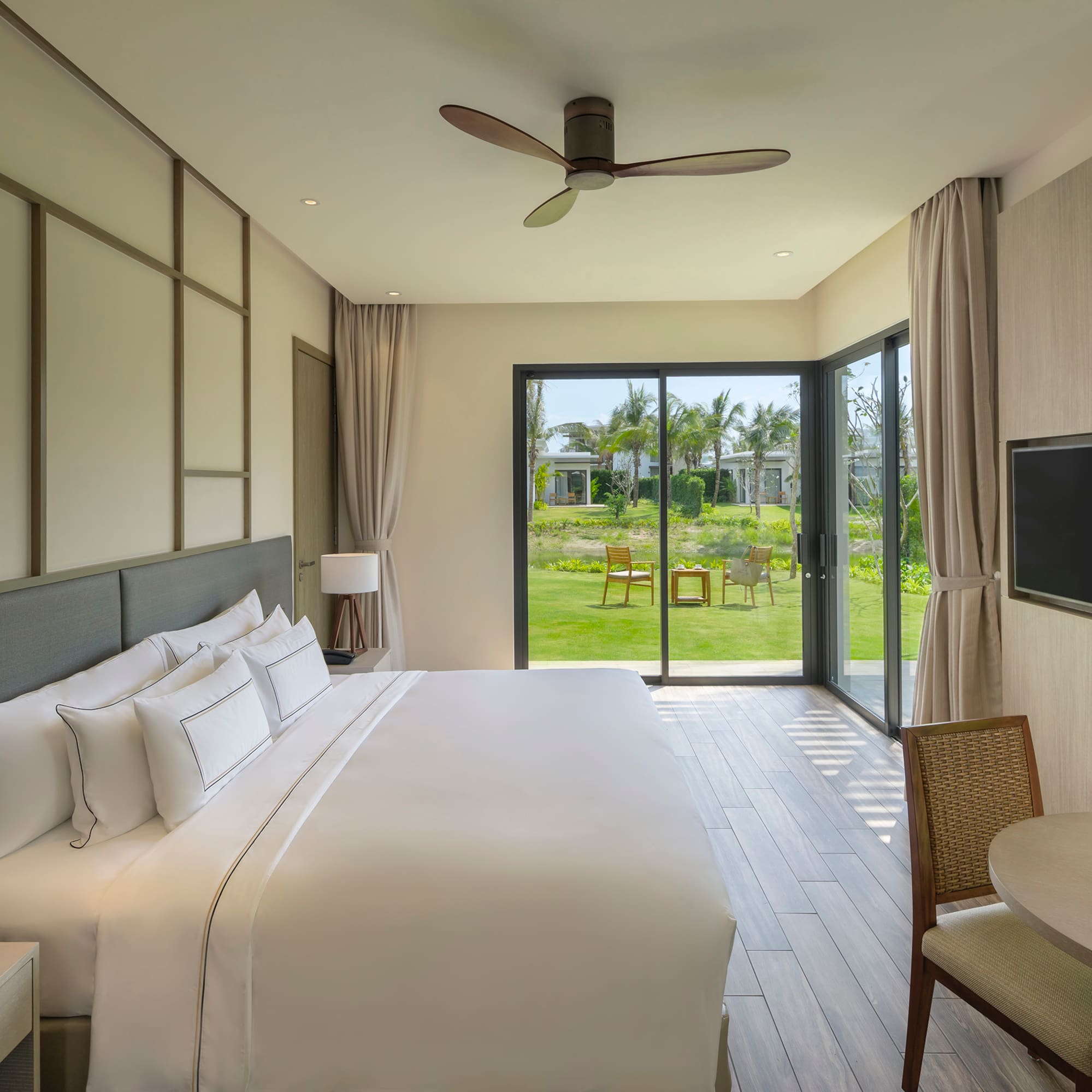 a bedroom with a large window and a table