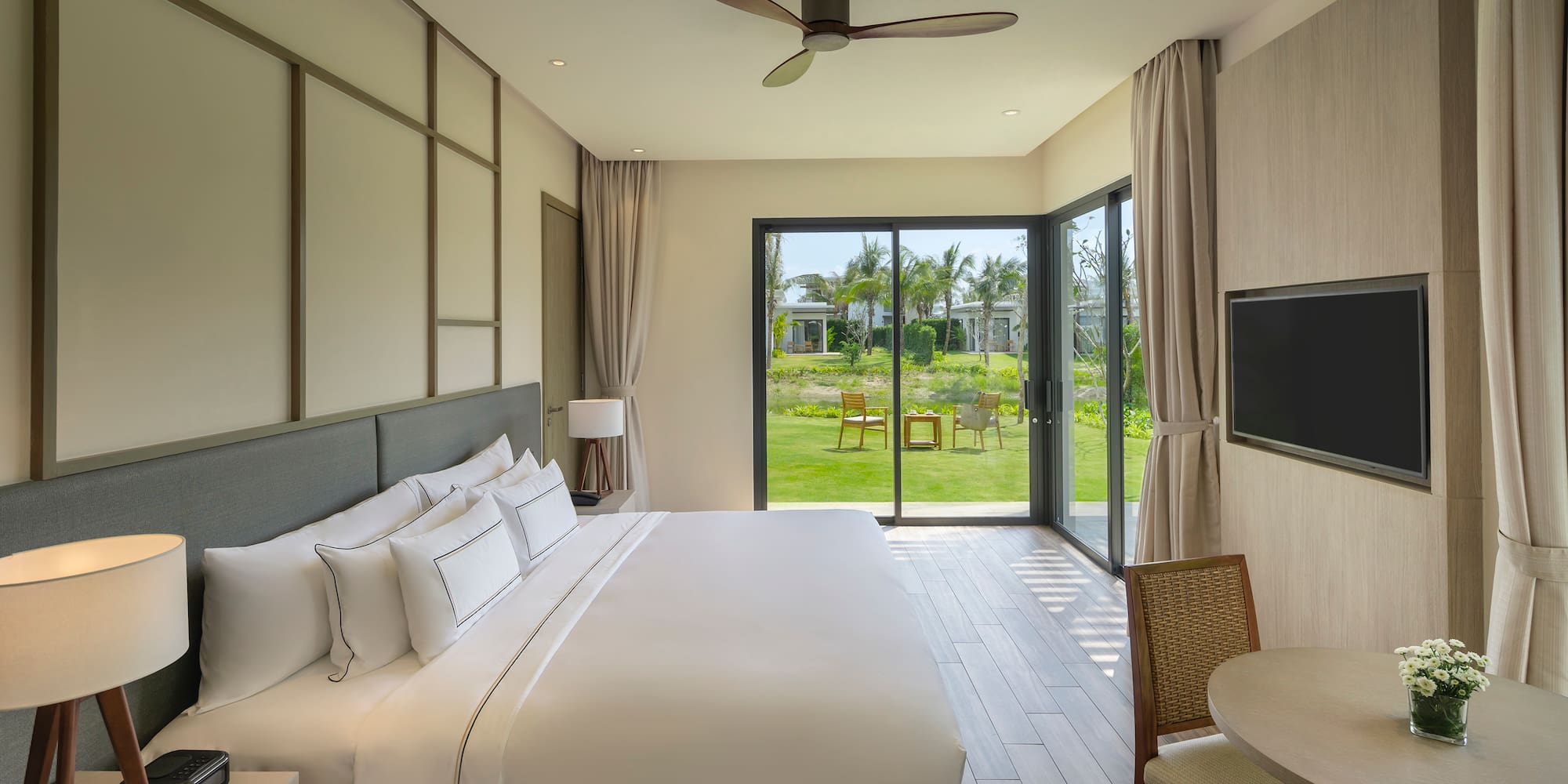 a bedroom with a large window and a table