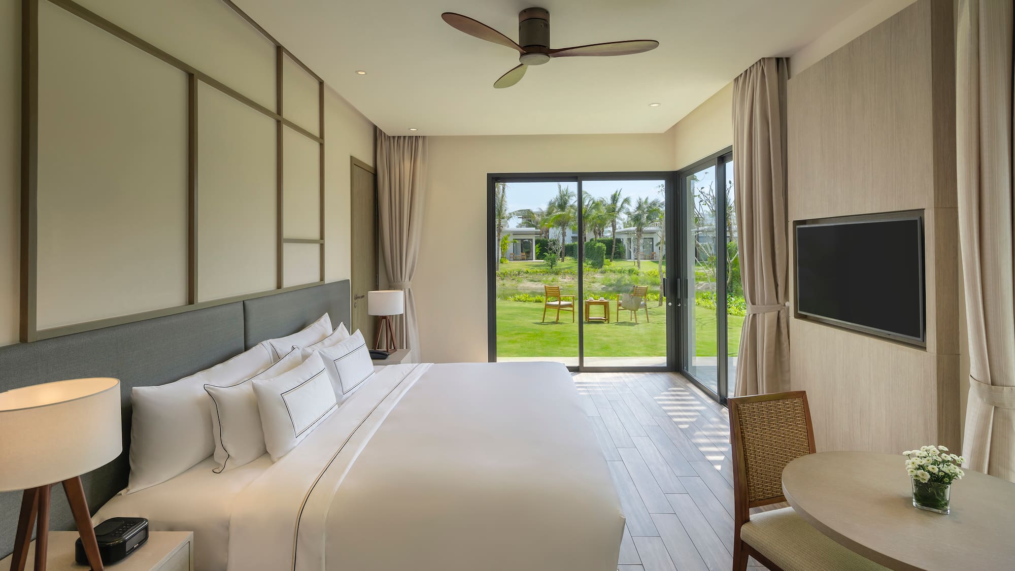 a bedroom with a large window and a table