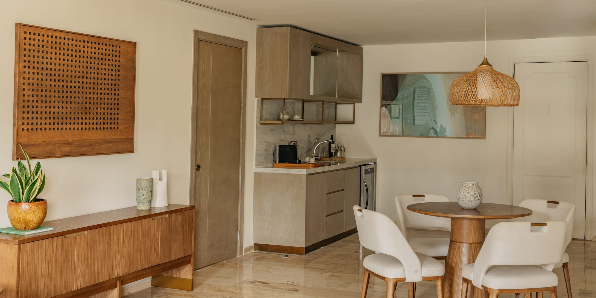 Modern apartment interior with kitchenette, dining set, and wood furniture.