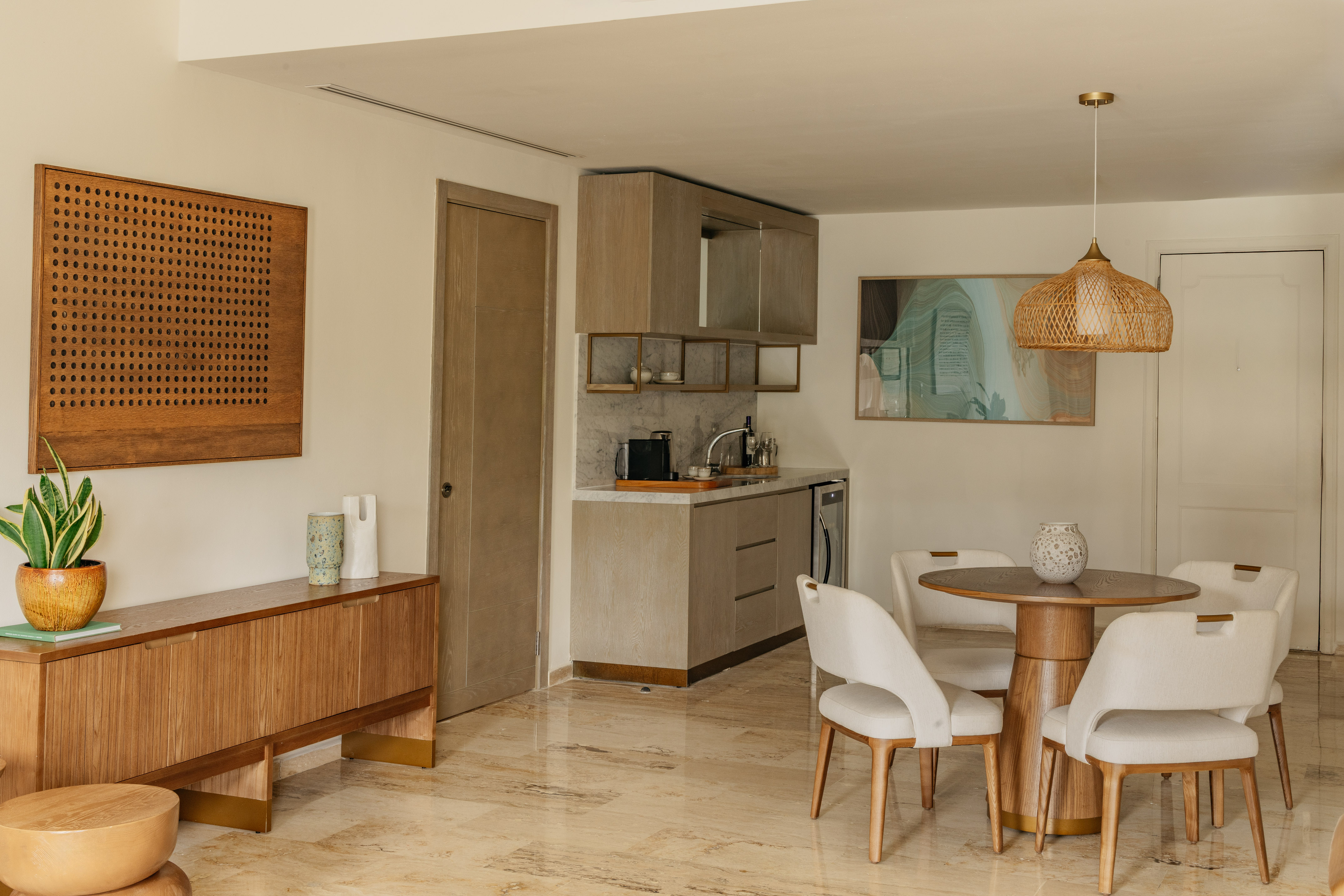 Modern apartment interior with kitchenette, dining set, and wood furniture.