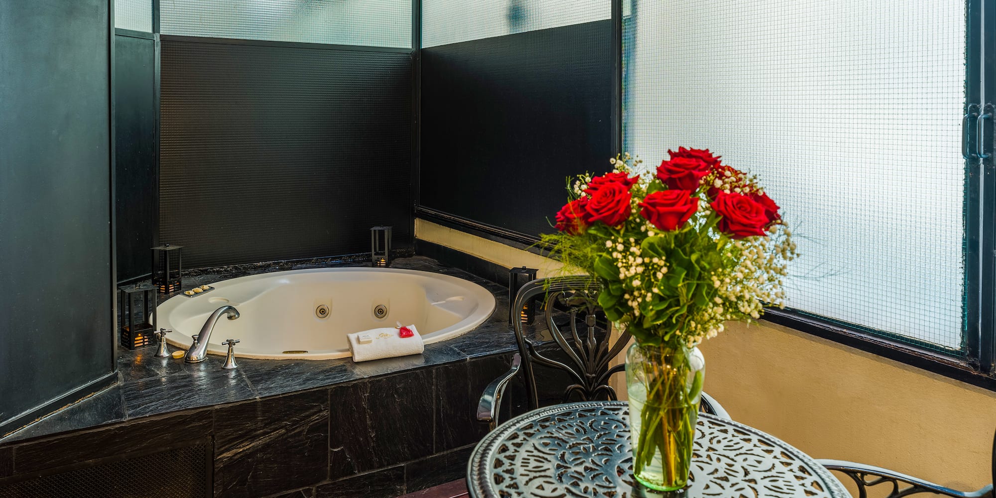 a vase of flowers on a table next to a hot tub