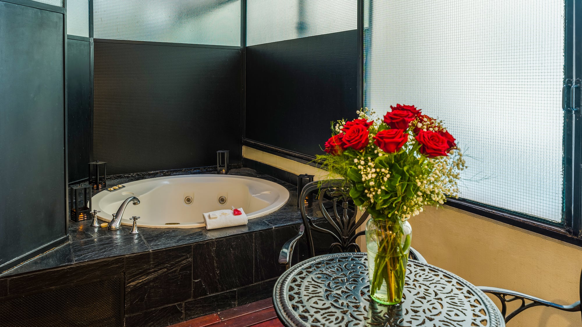 a vase of flowers on a table next to a hot tub