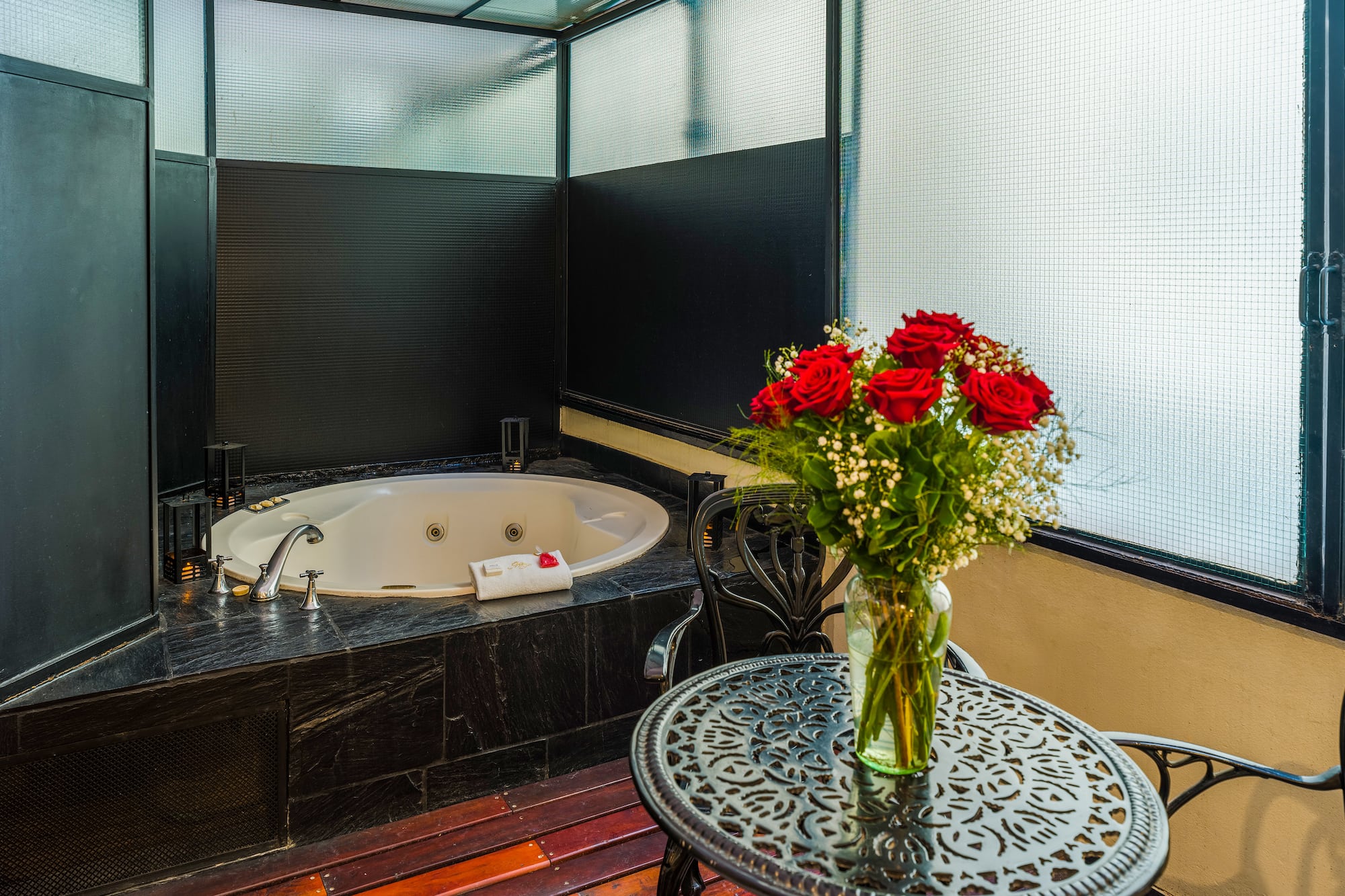 a vase of flowers on a table next to a hot tub