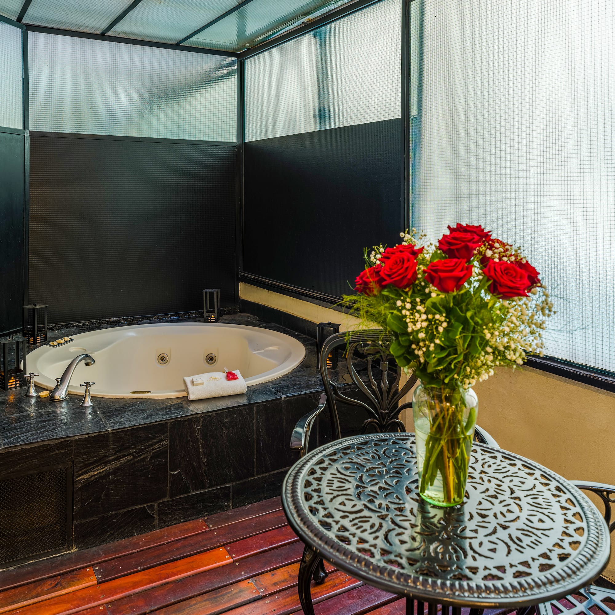 a vase of flowers on a table next to a hot tub