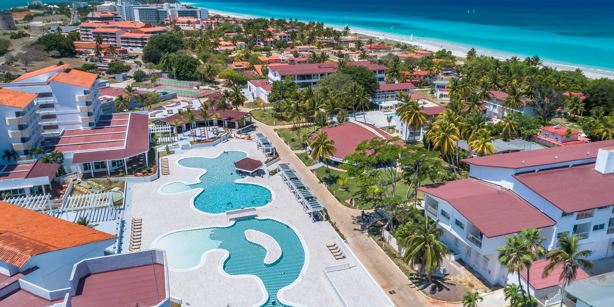 a swimming pool and buildings next to a beach