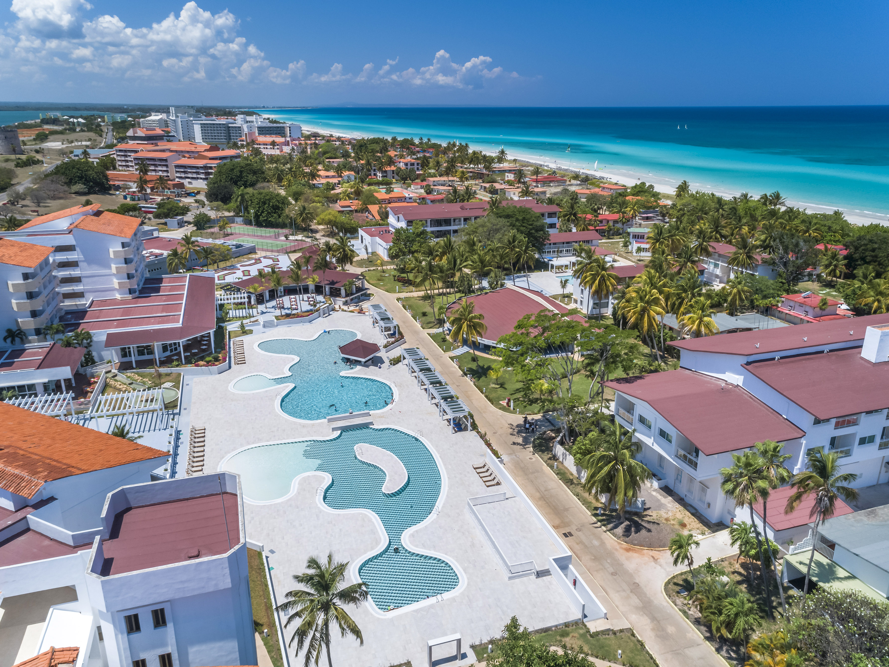 a swimming pool and buildings next to a beach