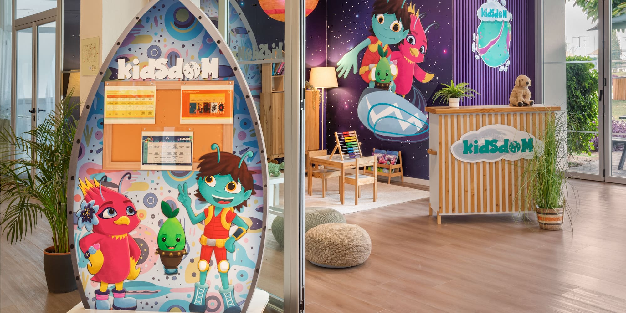 KidsdOM children's club entrance with space theme, colorful characters, and play area.