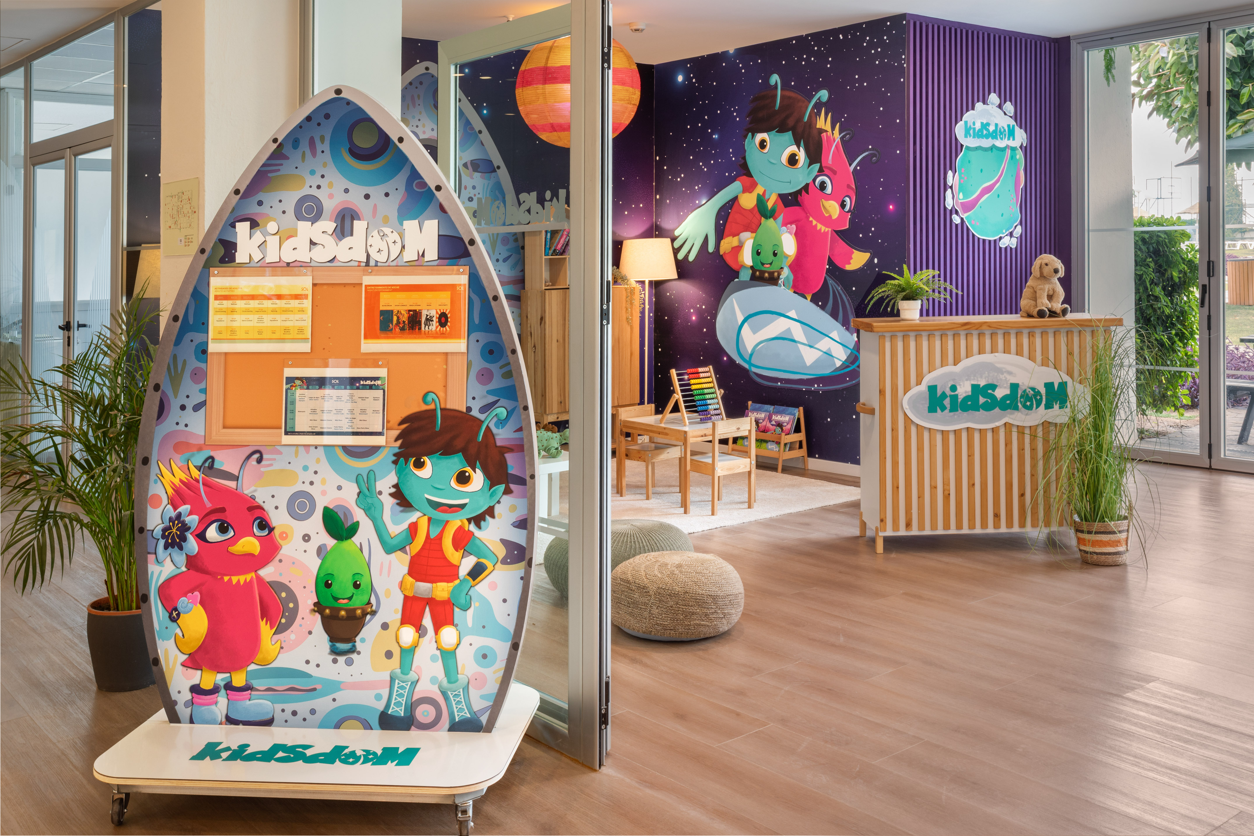 KidsdOM children's club entrance with space theme, colorful characters, and play area.