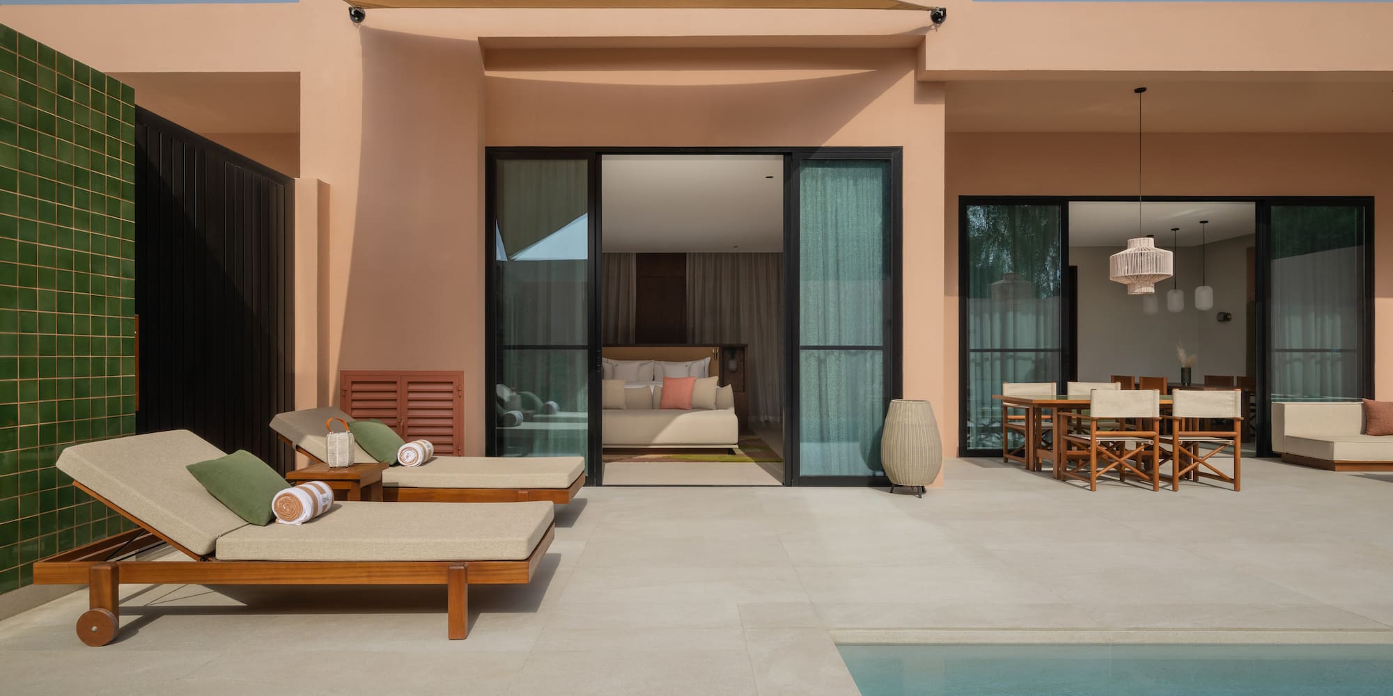 a pool and lounge chairs outside of a house