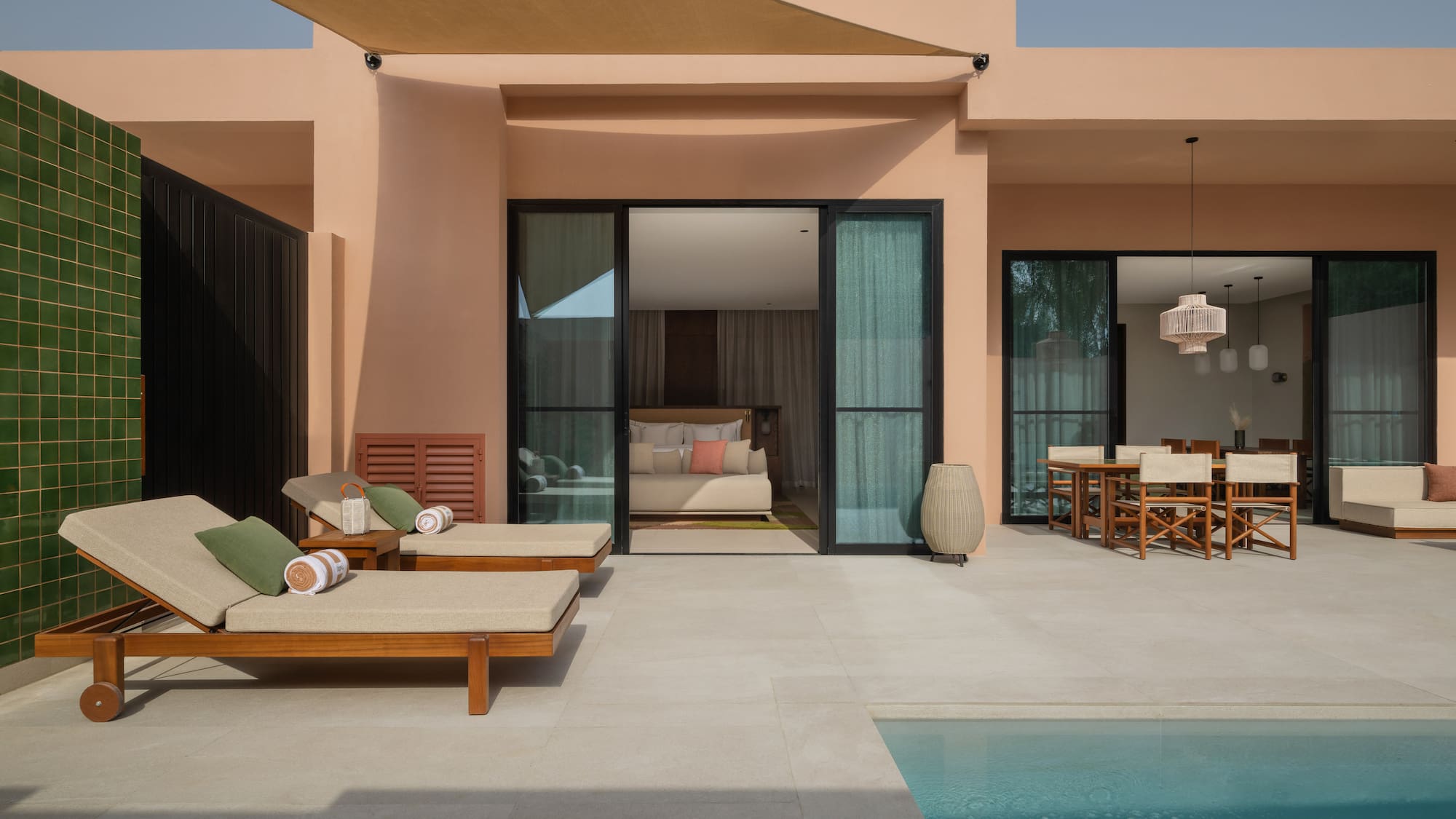 a pool and lounge chairs outside of a house