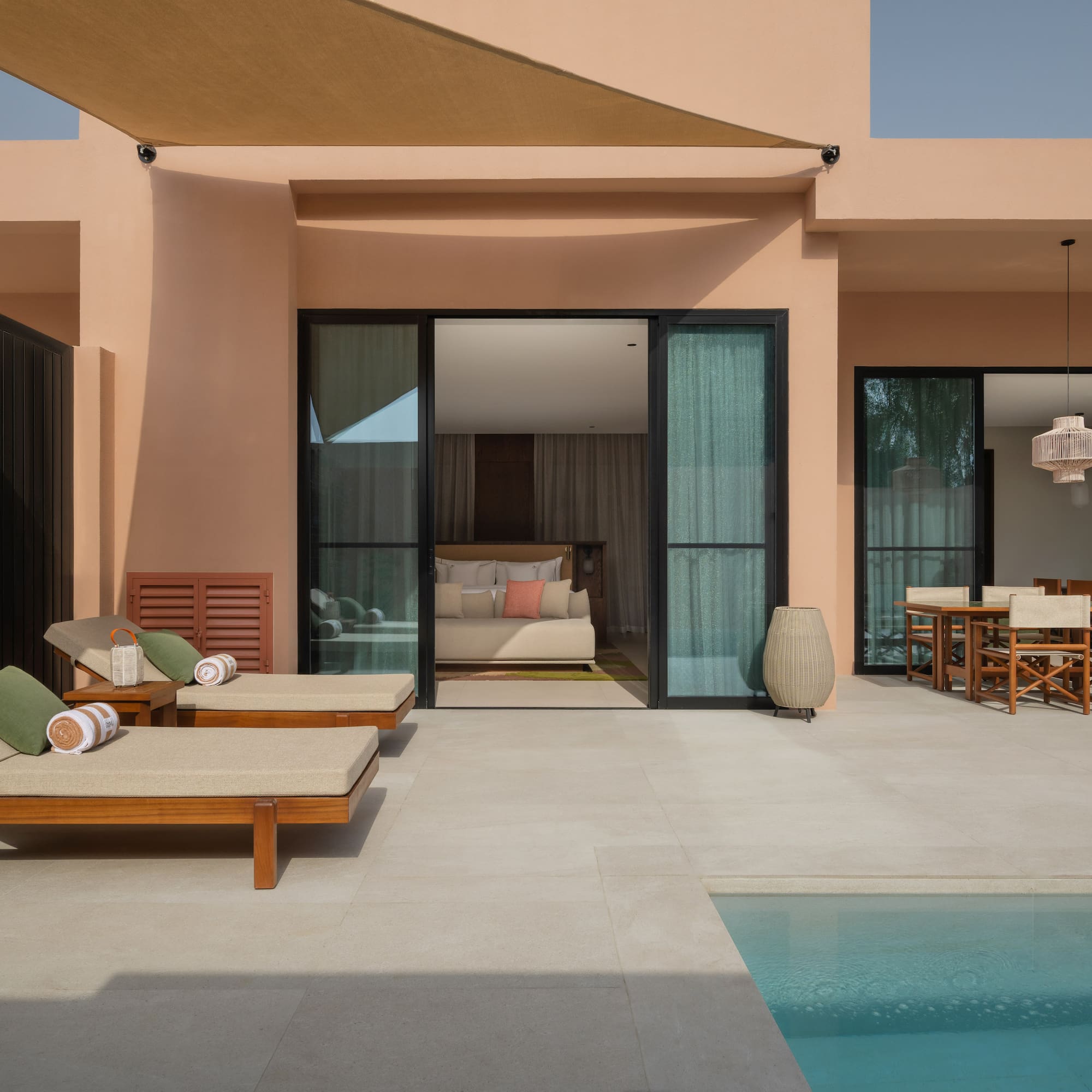 a pool and lounge chairs outside of a house