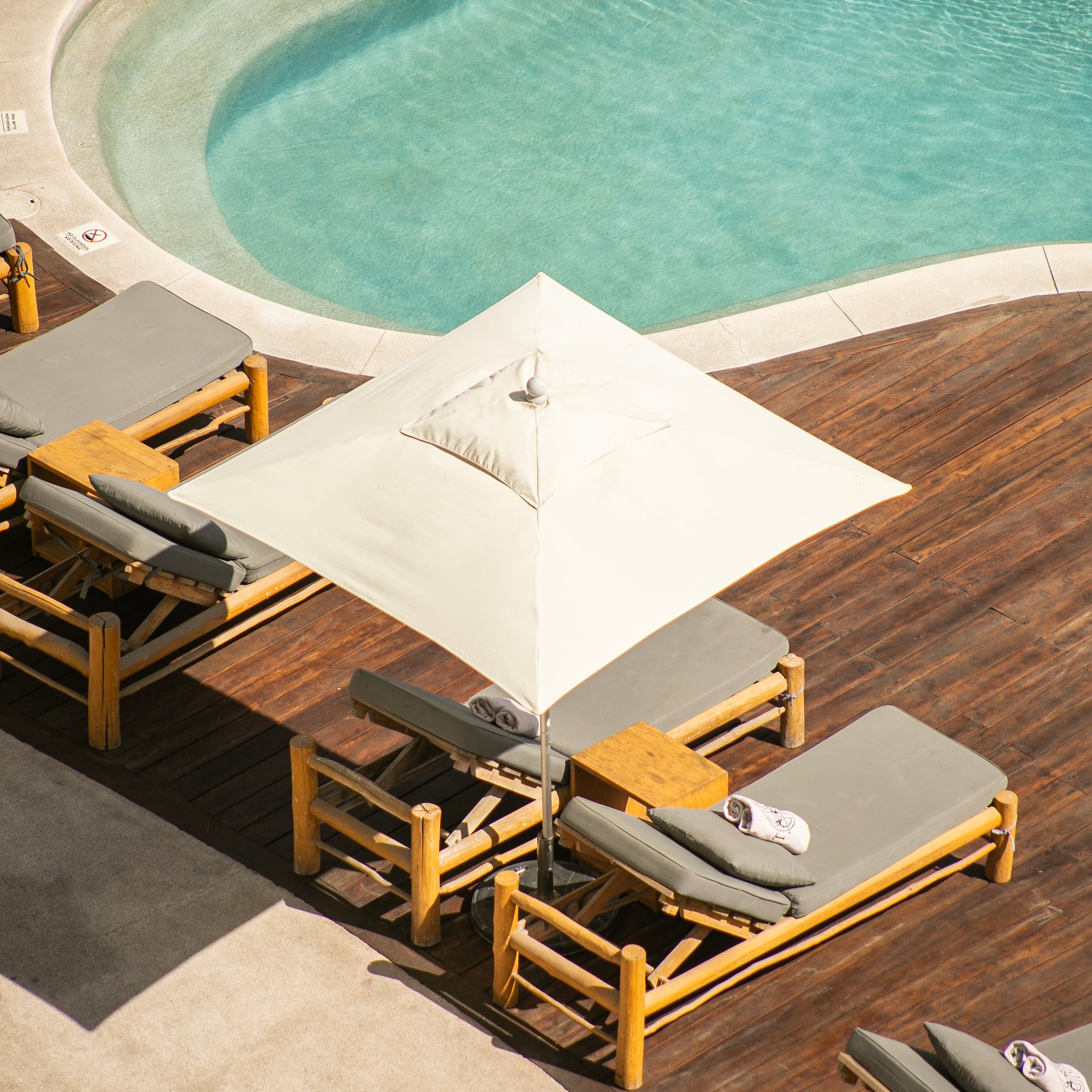 a pool with lounge chairs and umbrella
