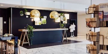 a store with a black wall and gold balls from the ceiling