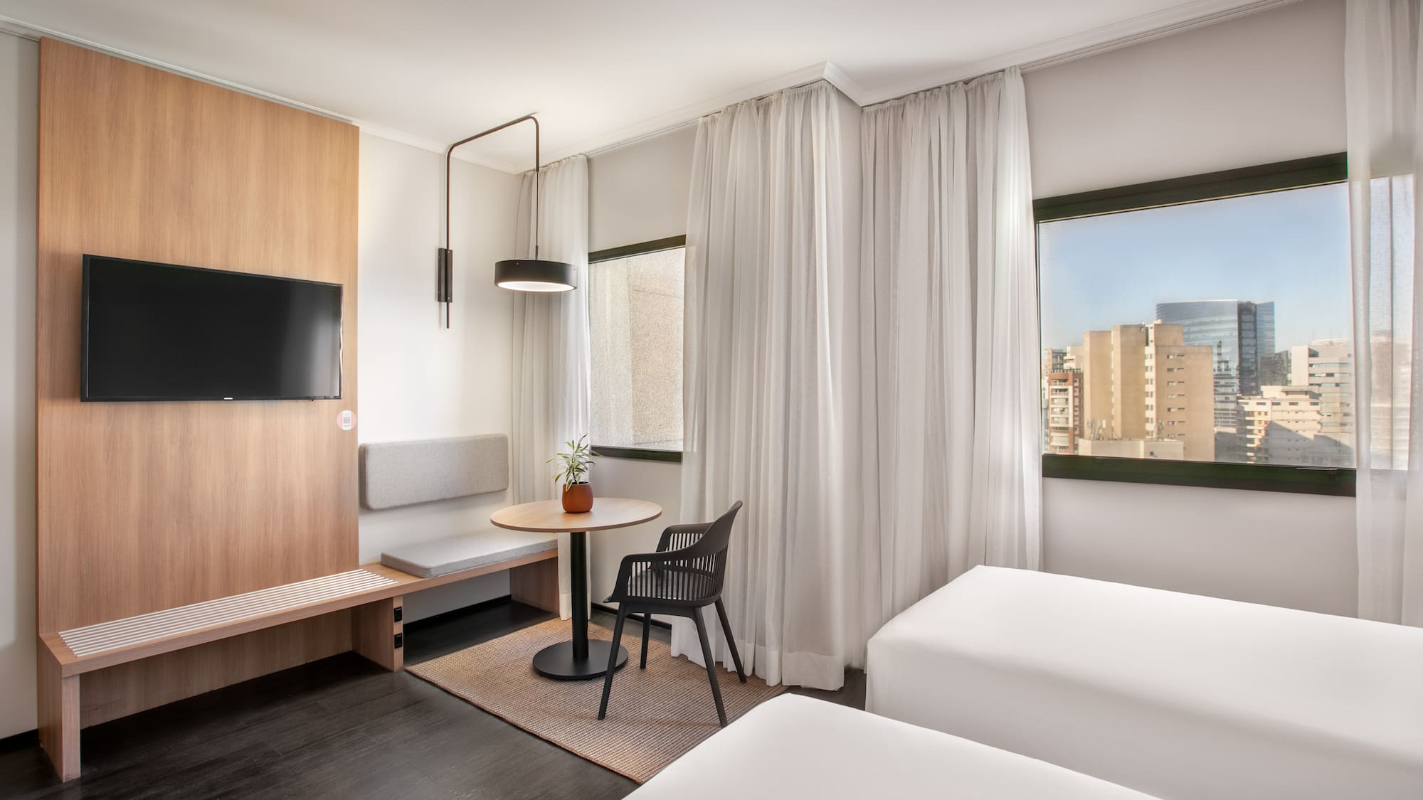 a room with two beds and a table and a tv