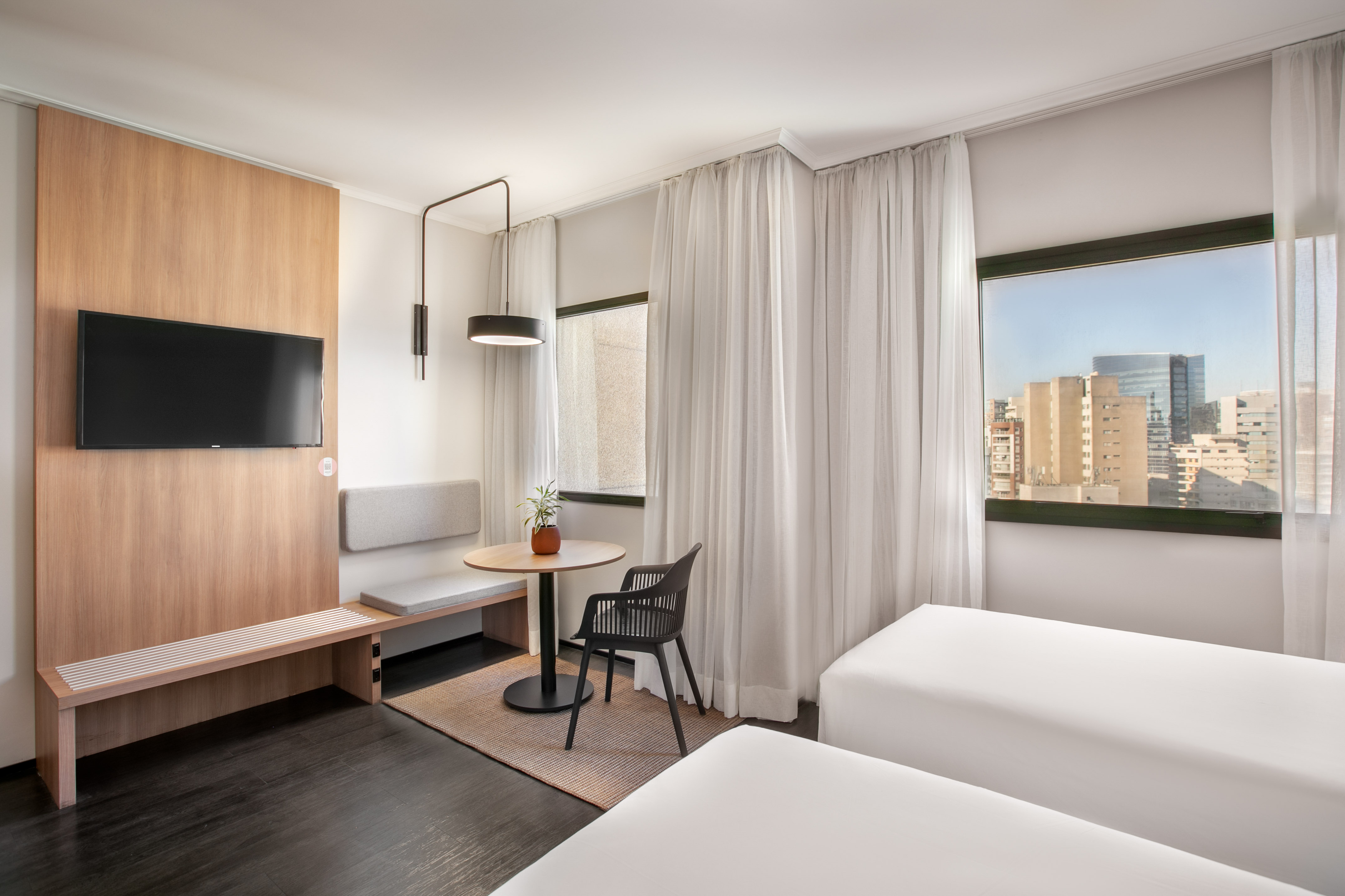 a room with two beds and a table and a tv