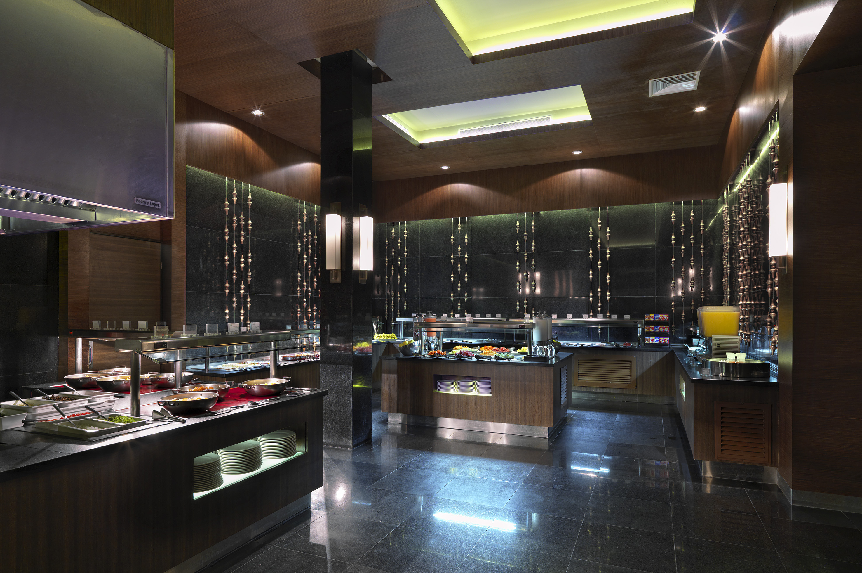 Spacious, modern hotel buffet dining area with various food stations.