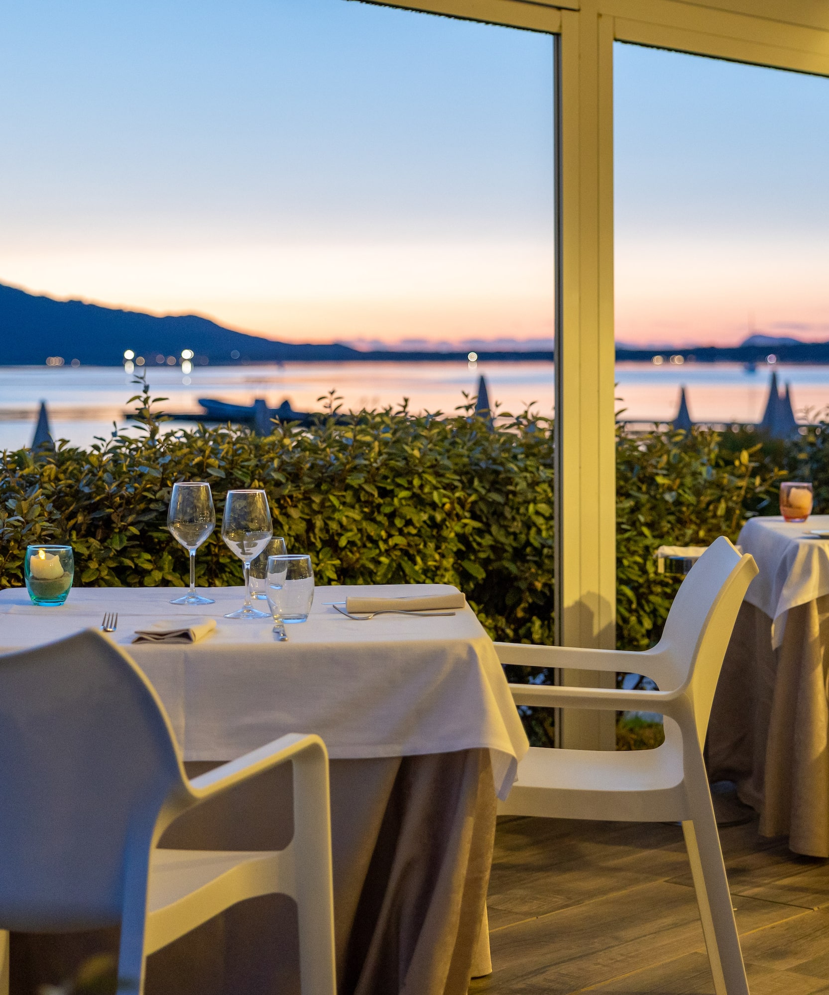 a table set up with wine glasses and a view of the water