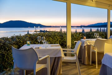 a table set up with wine glasses and a view of the water