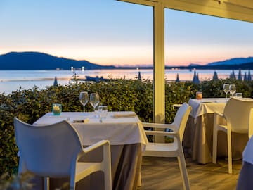 a table set up with wine glasses and a view of the water