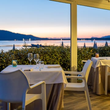 a table set up with wine glasses and a view of the water
