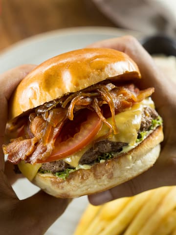 a person holding a burger