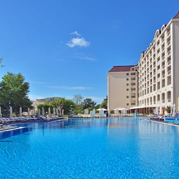 a large pool with chairs and umbrellas in front of a building