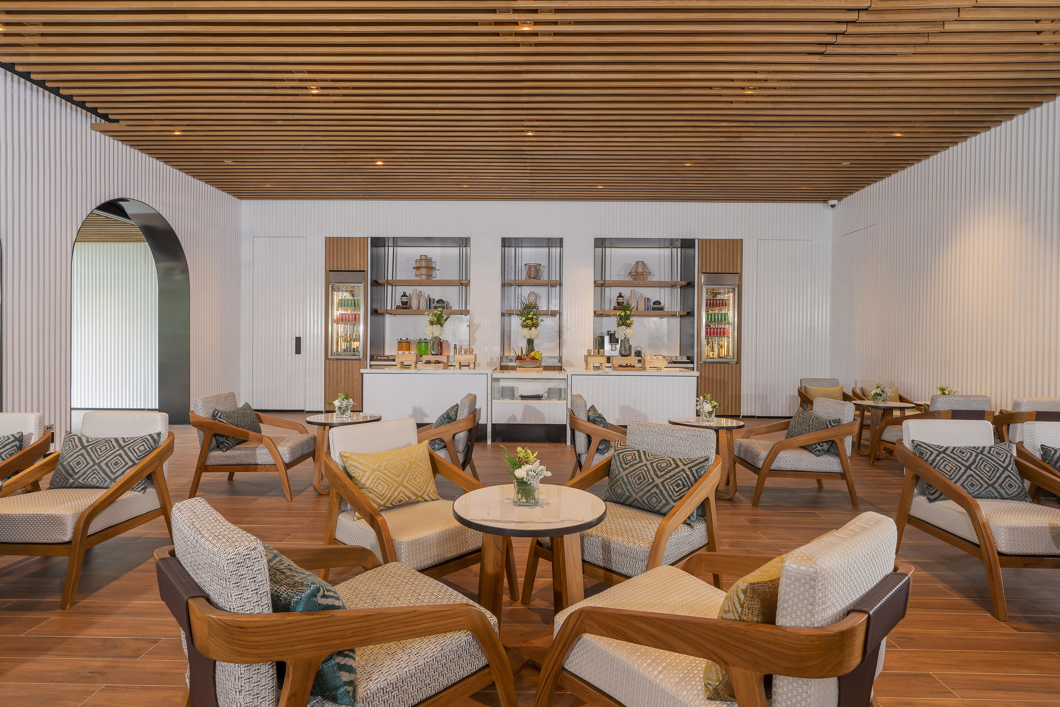 Modern lounge with comfortable seating, wooden ceiling, and elegant buffet setup.