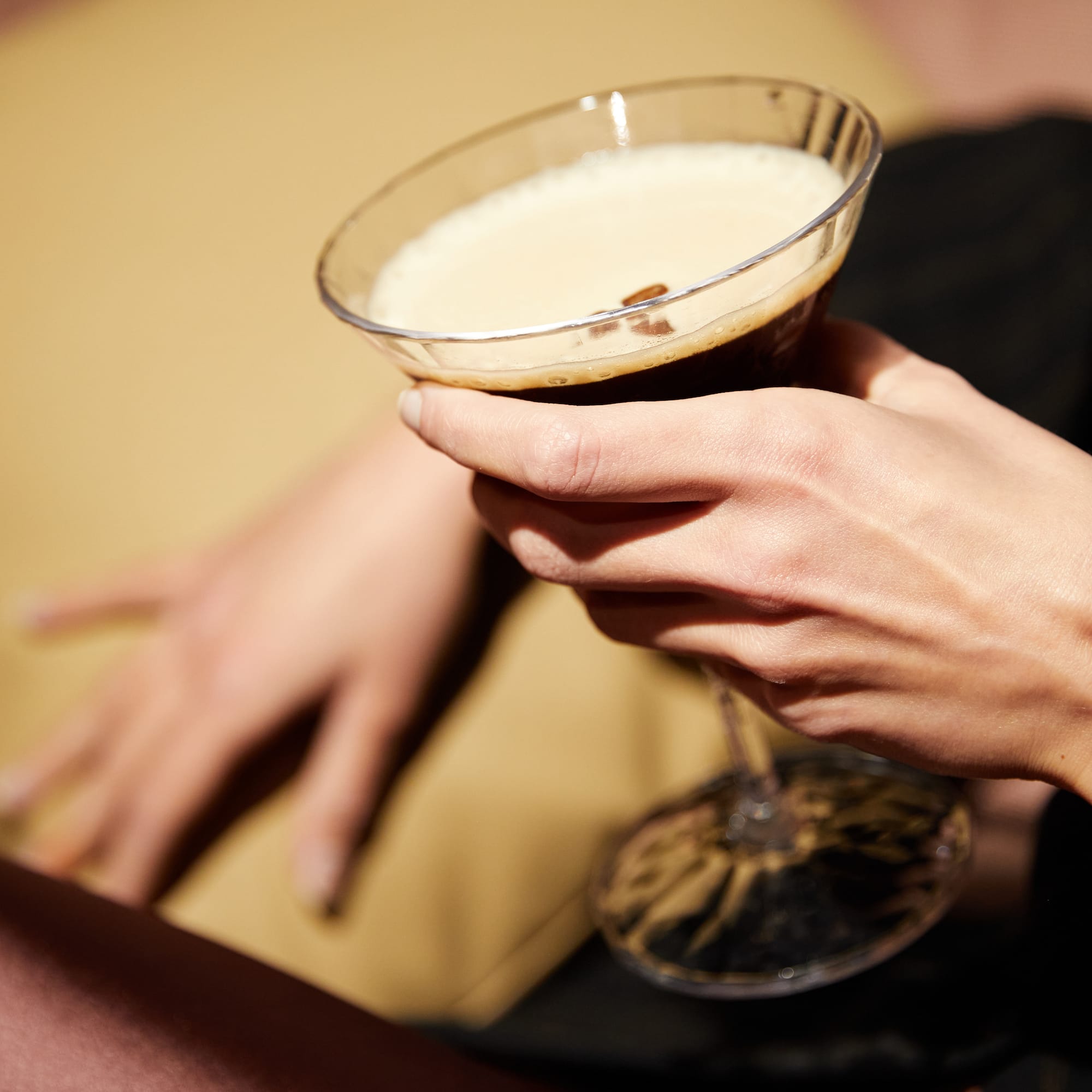 a person holding a glass of liquid