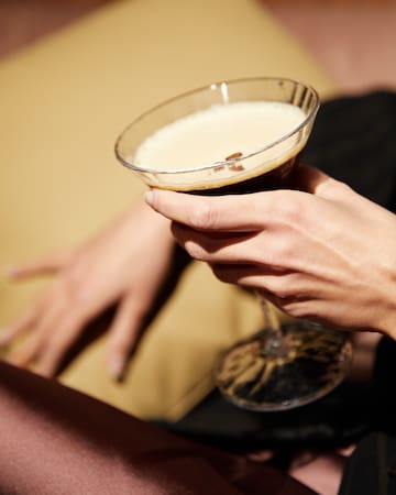 a person holding a glass of liquid