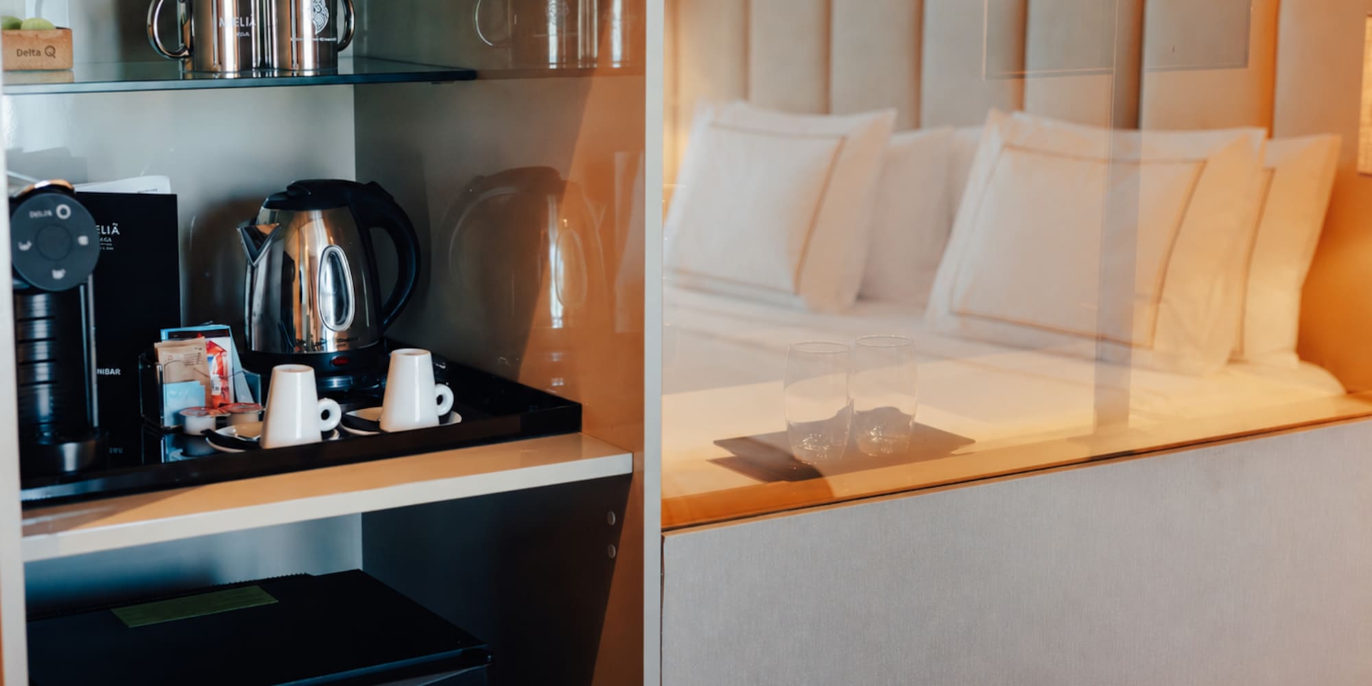Hotel room with coffee machine, kettle, minibar, and a comfortable bed.