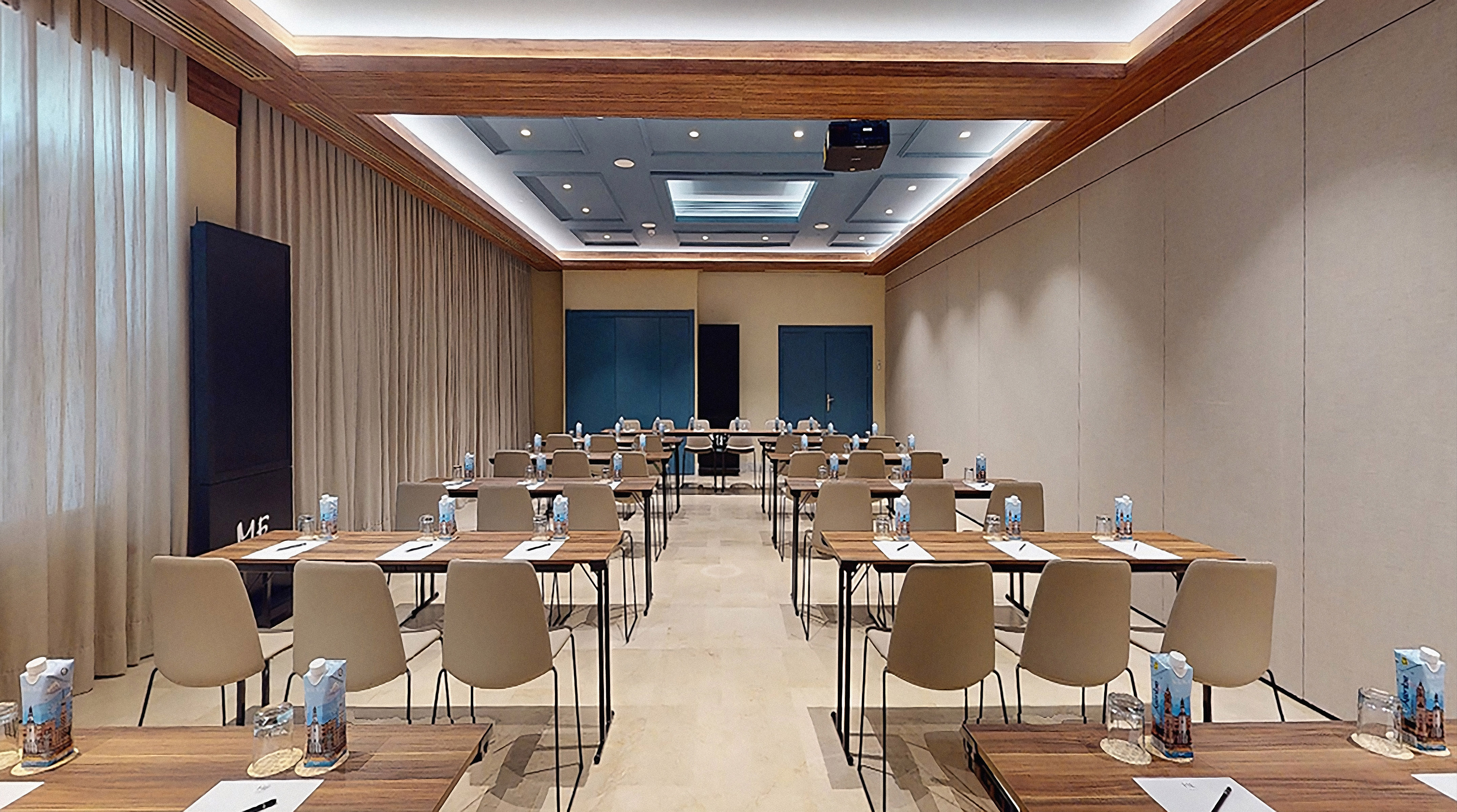 Modern conference room, classroom style setup, tables, chairs, projector.