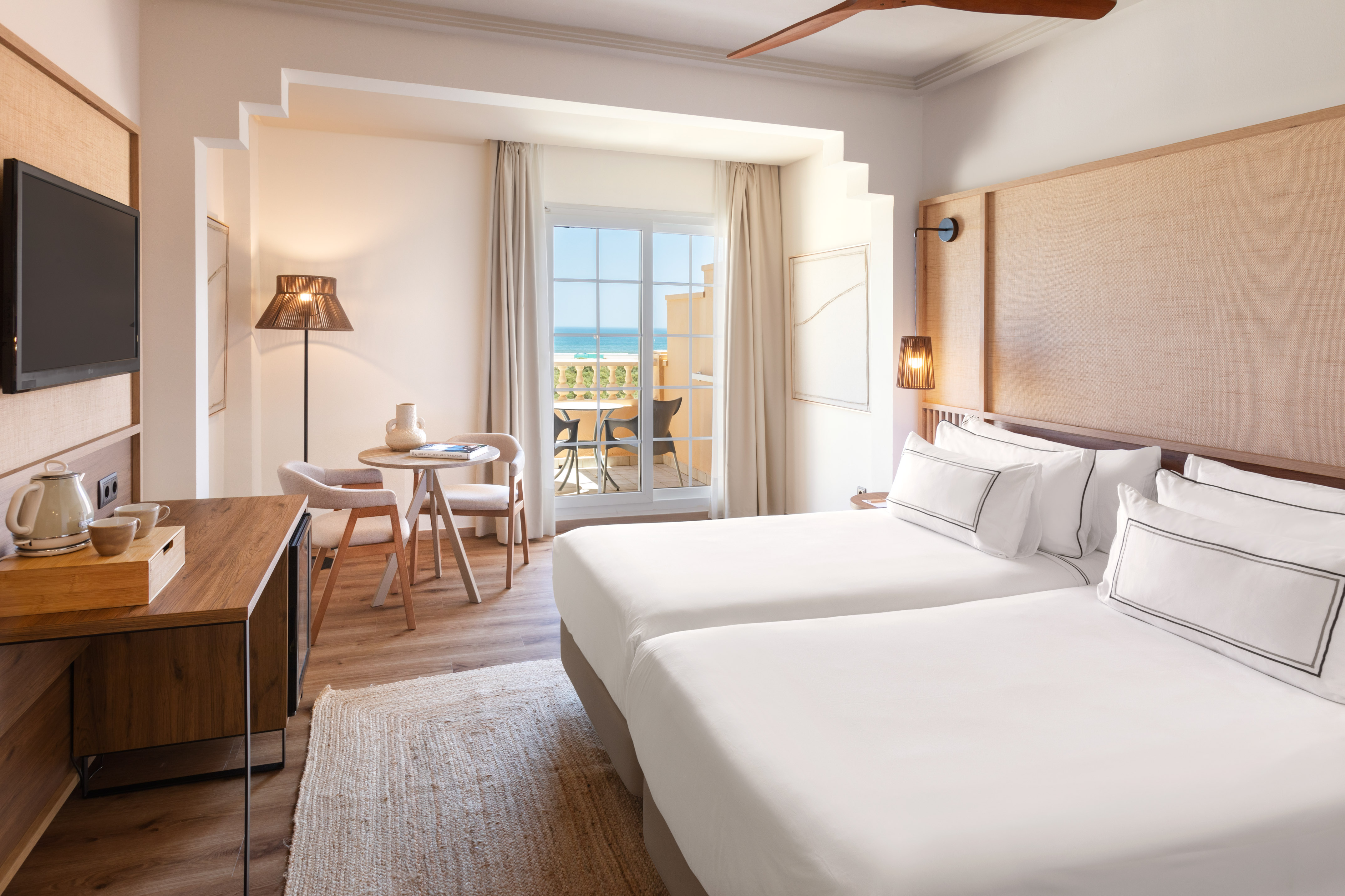 a room with two beds and a table and chairs