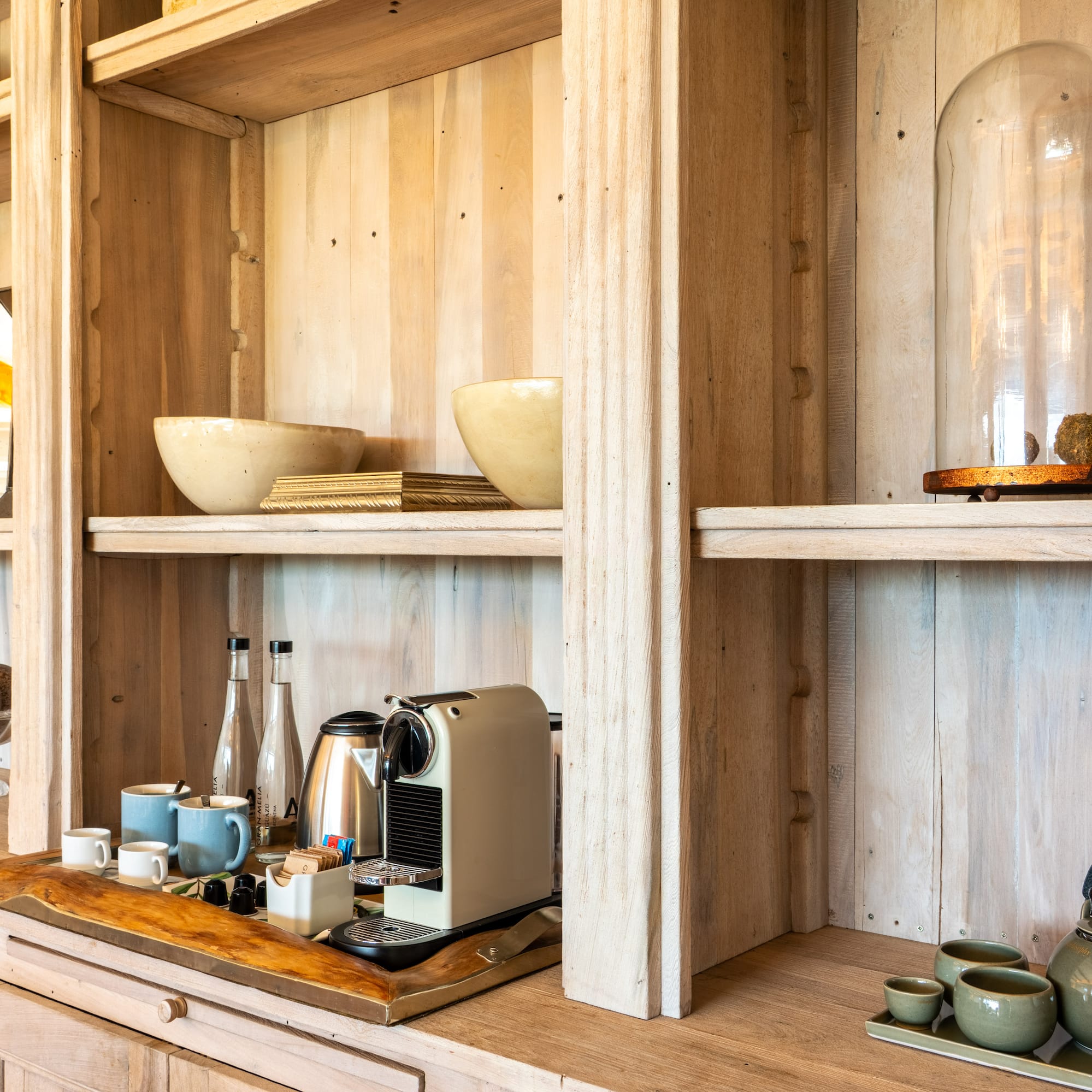 a shelf with a coffee maker and cups on it