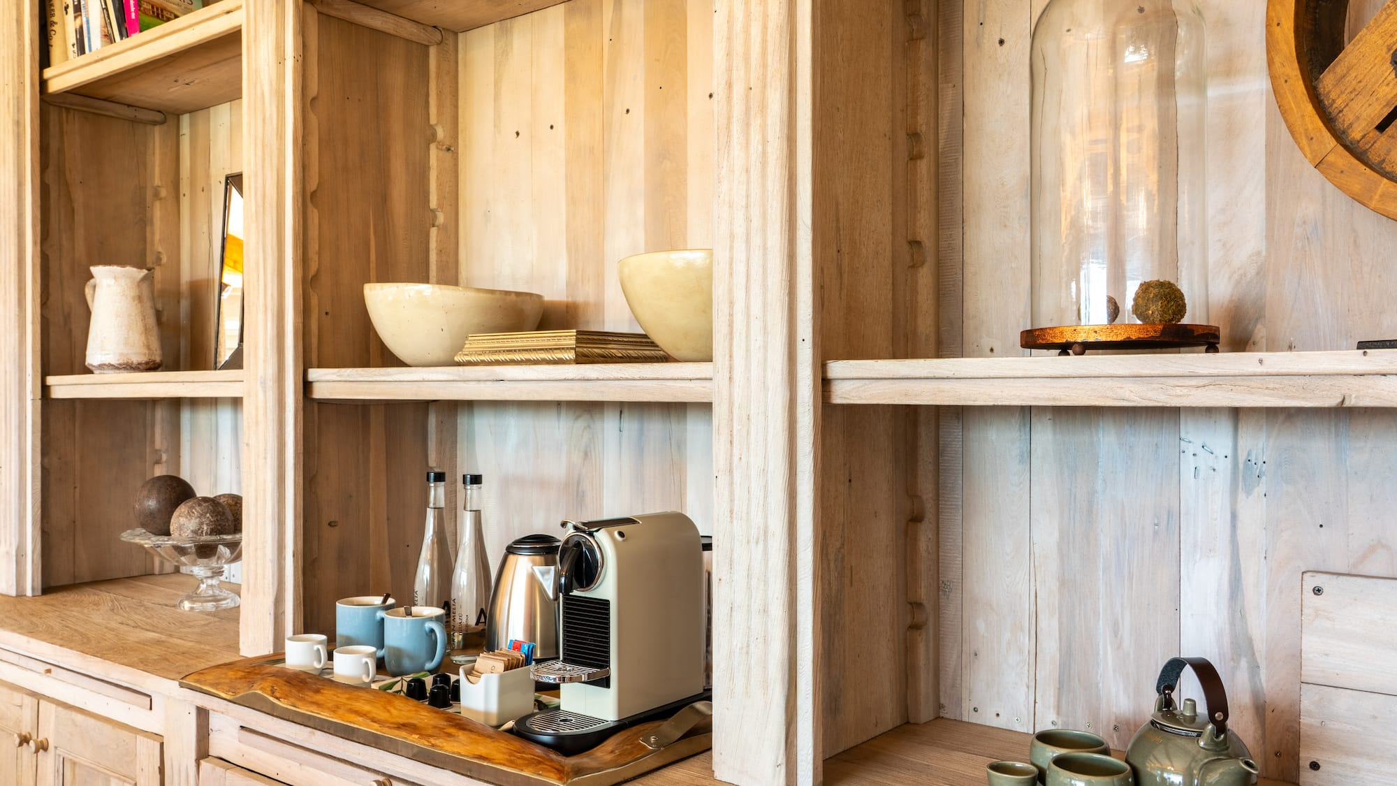 a shelf with a coffee maker and cups on it