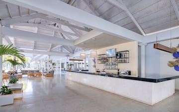 a large white room with a bar and a large white ceiling
