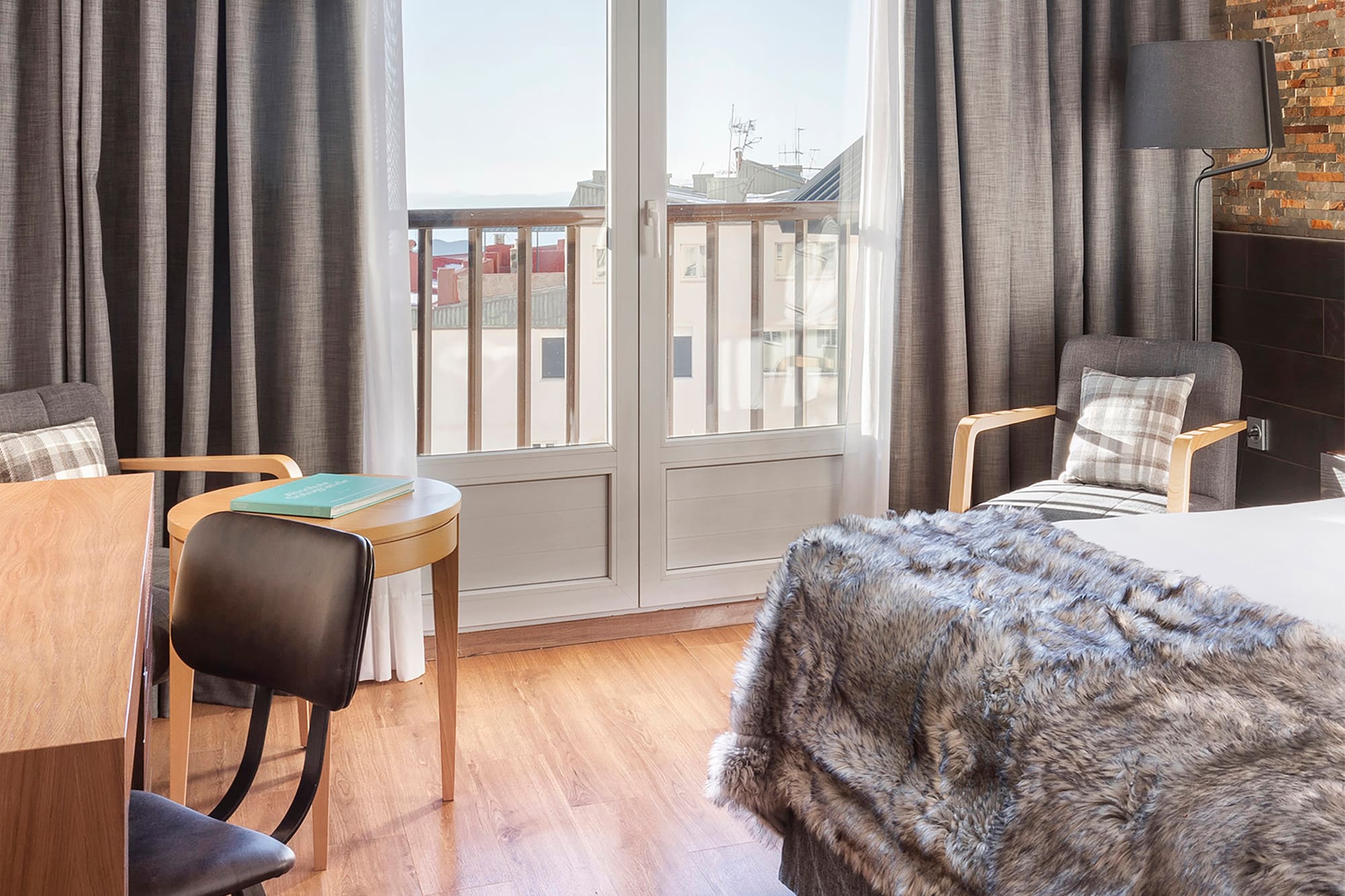 a bedroom with a bed and chairs and a table