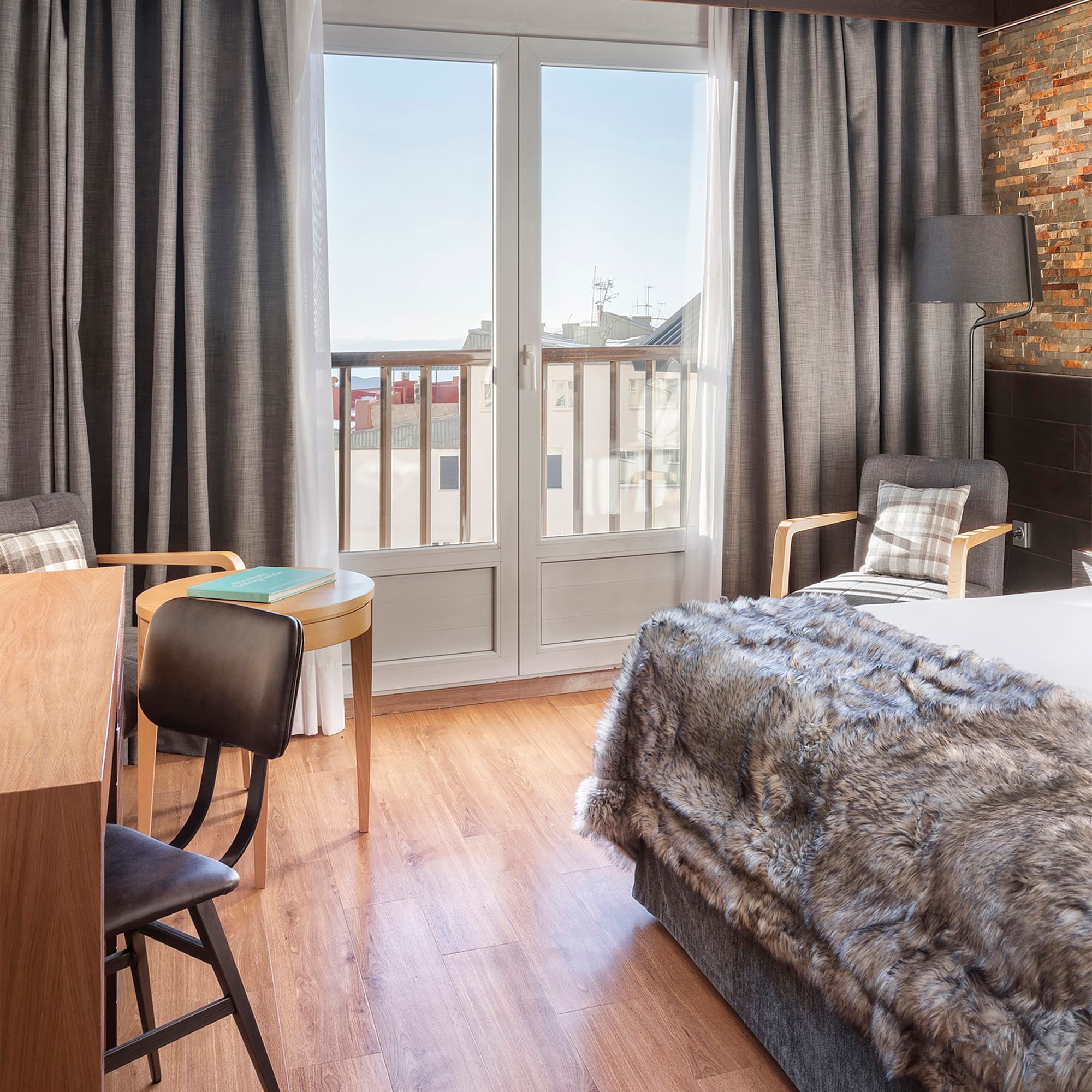 a bedroom with a bed and chairs and a table