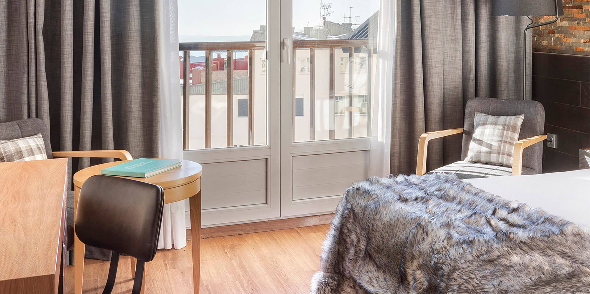 a bedroom with a bed and chairs and a table