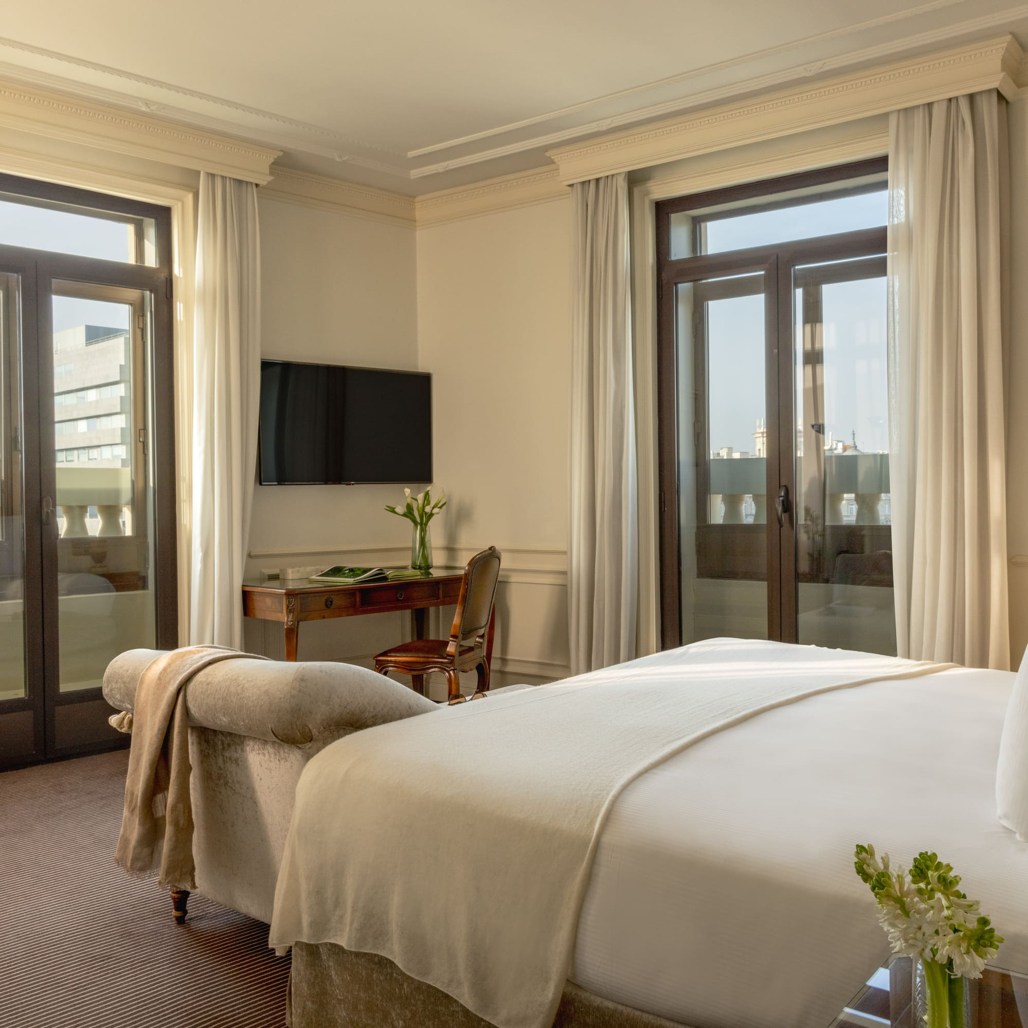 a bedroom with a bed and a desk and a television