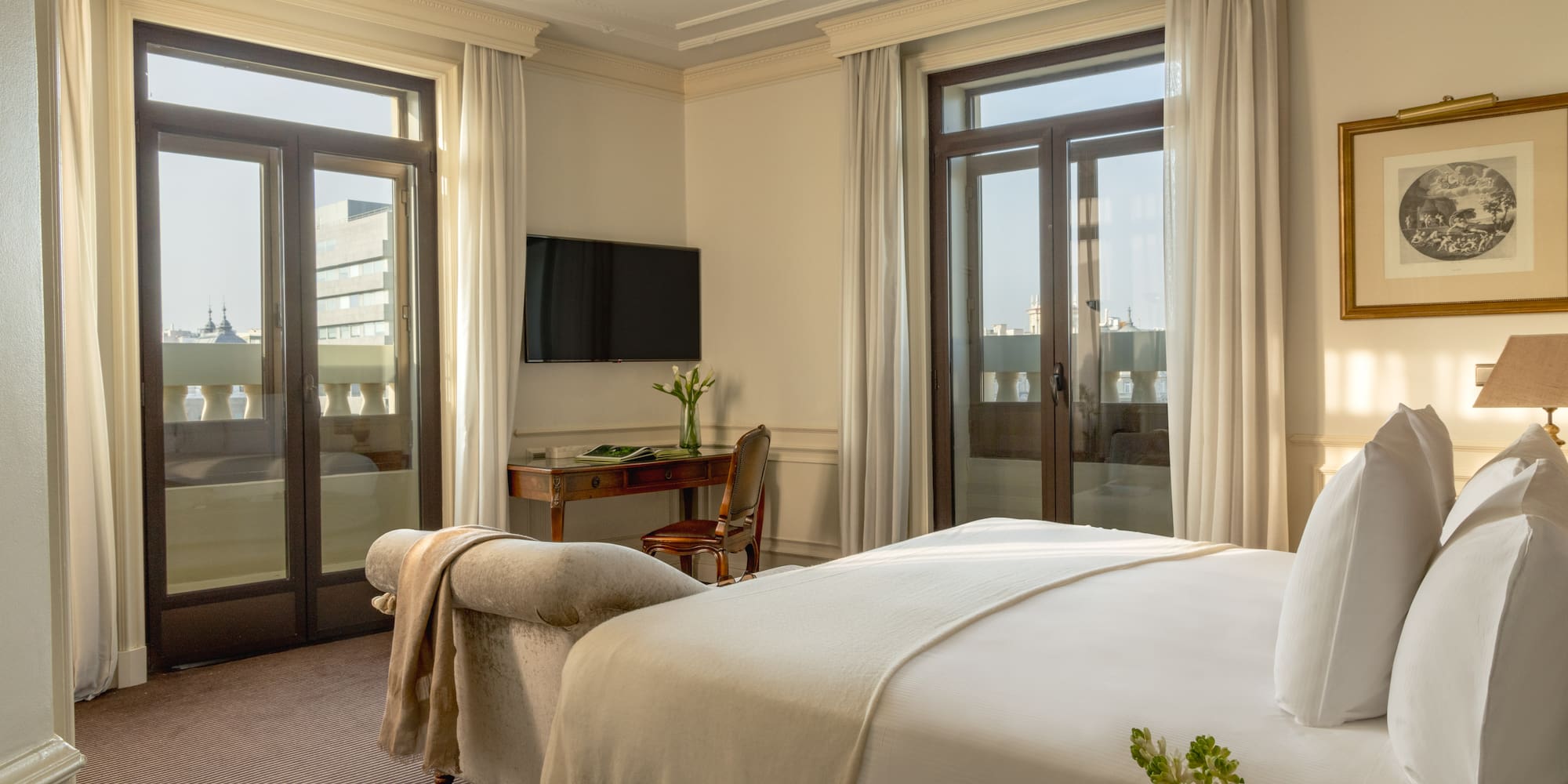 a bedroom with a bed and a desk and a television