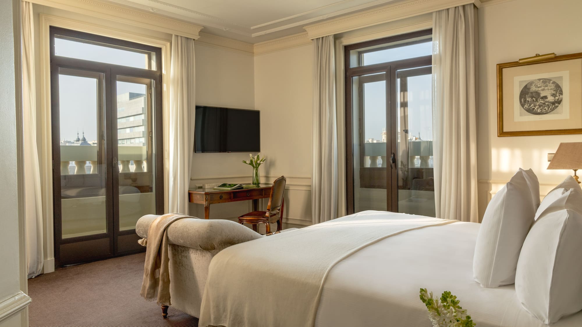 a bedroom with a bed and a desk and a television