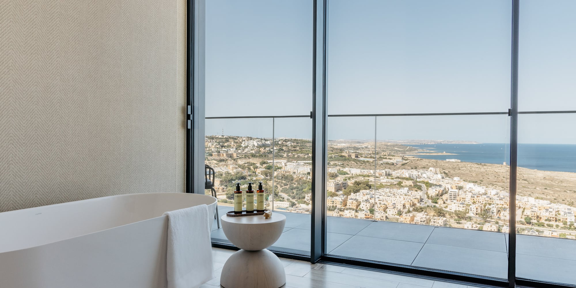 a bathroom with a tub and a bathtub overlooking a city