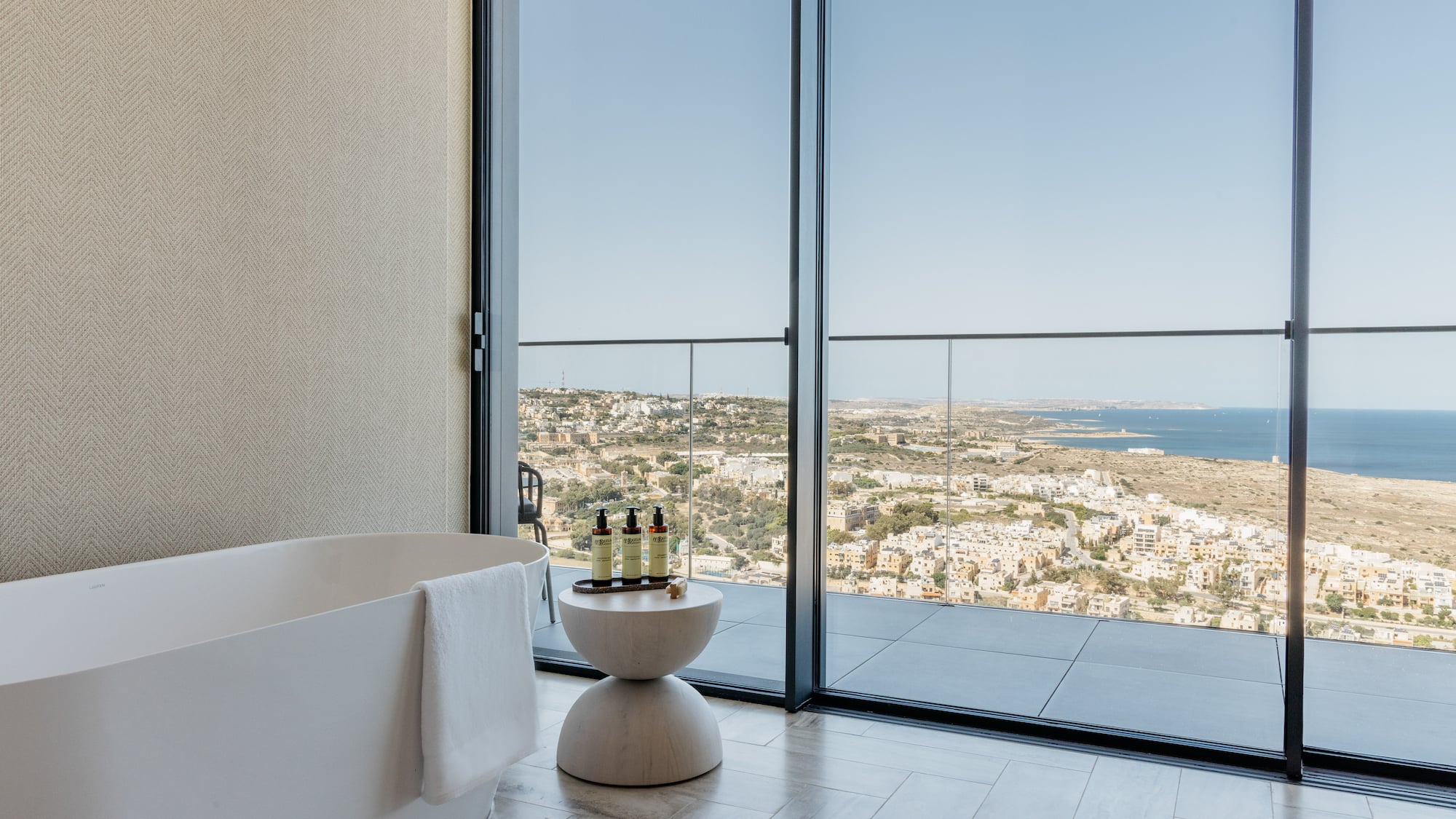 a bathroom with a tub and a bathtub overlooking a city